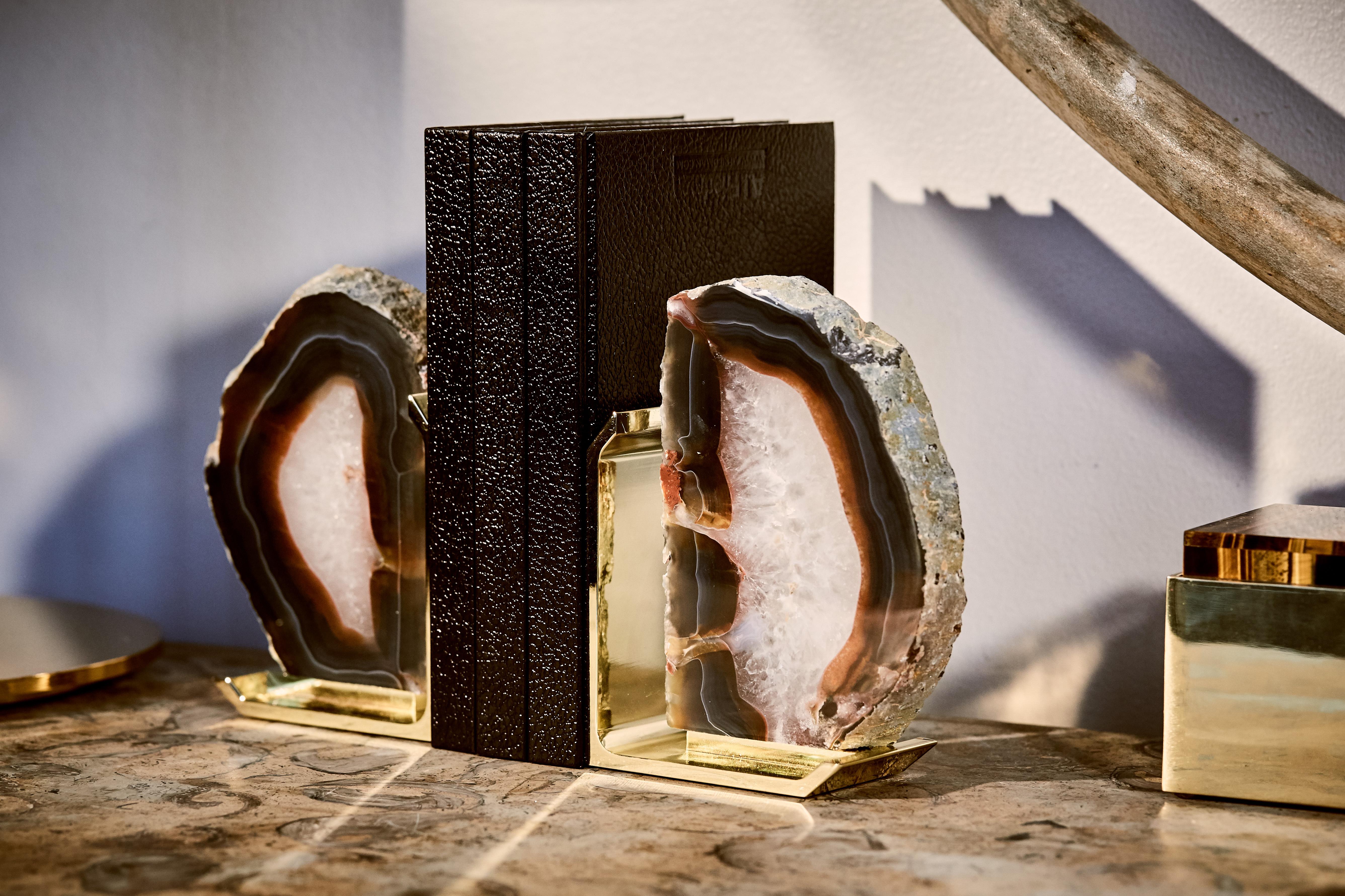 Modernity and nature combine in the design of our Fim bookends. Striking variations of color differentiate the stones of these pieces. The gems are natural outgrowths from the inside of ancient lava streams, with traces of crystal, agate, and