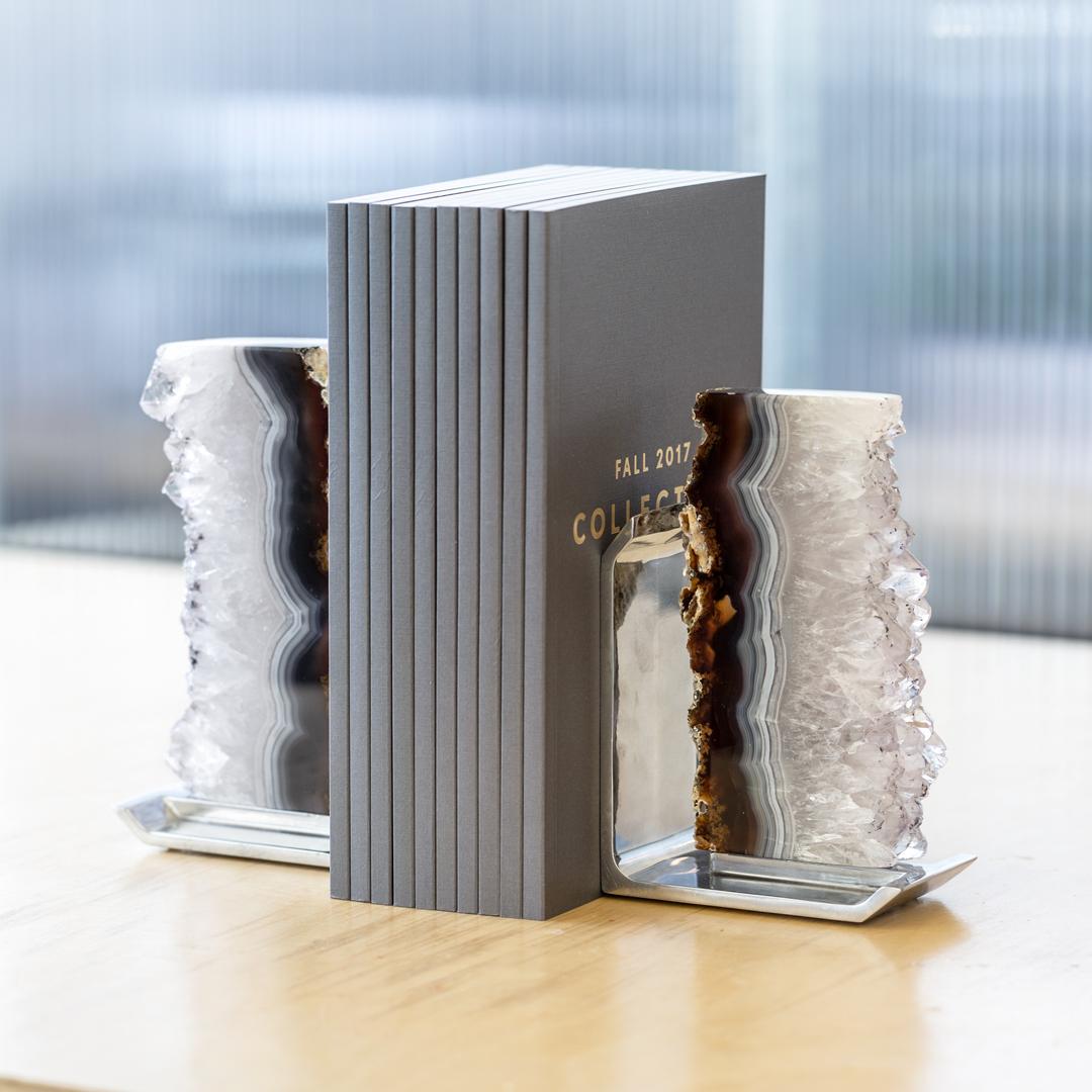 Modernity and nature combine in the design of our Fim bookends. Striking variations of color differentiate the stones of these pieces. The gems are natural outgrowths from the inside of ancient lava streams, with traces of crystal, agate and