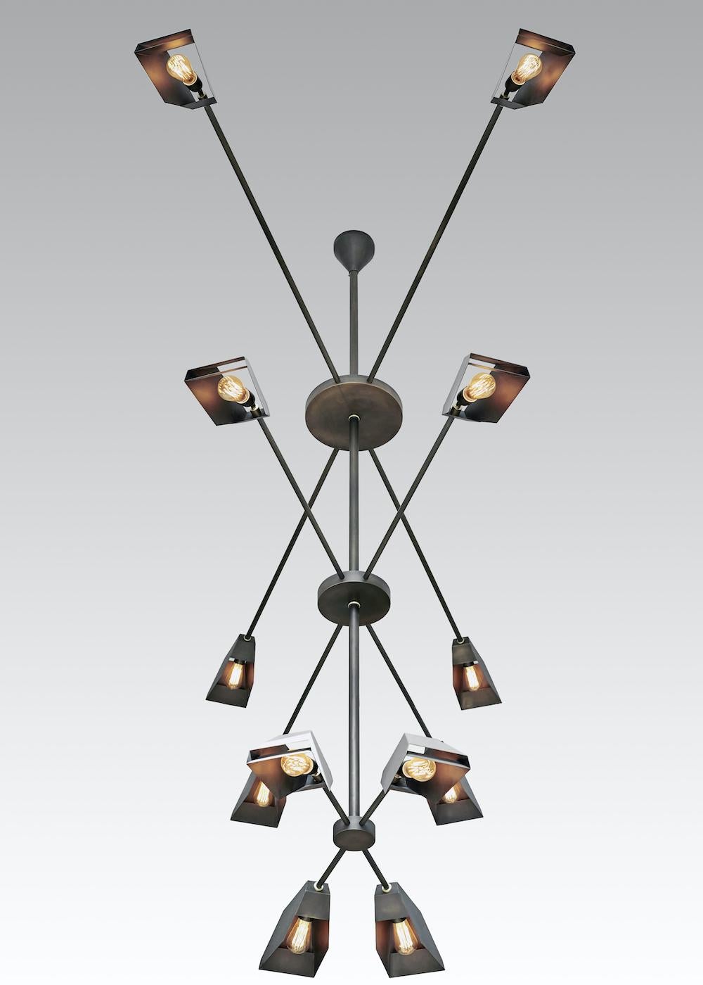 This is a custom chandelier with a patinated brass body. Each fixture is designed and made to each client's preferences according to overall shape, number of tiers, reflectors and fins, and brass finish.