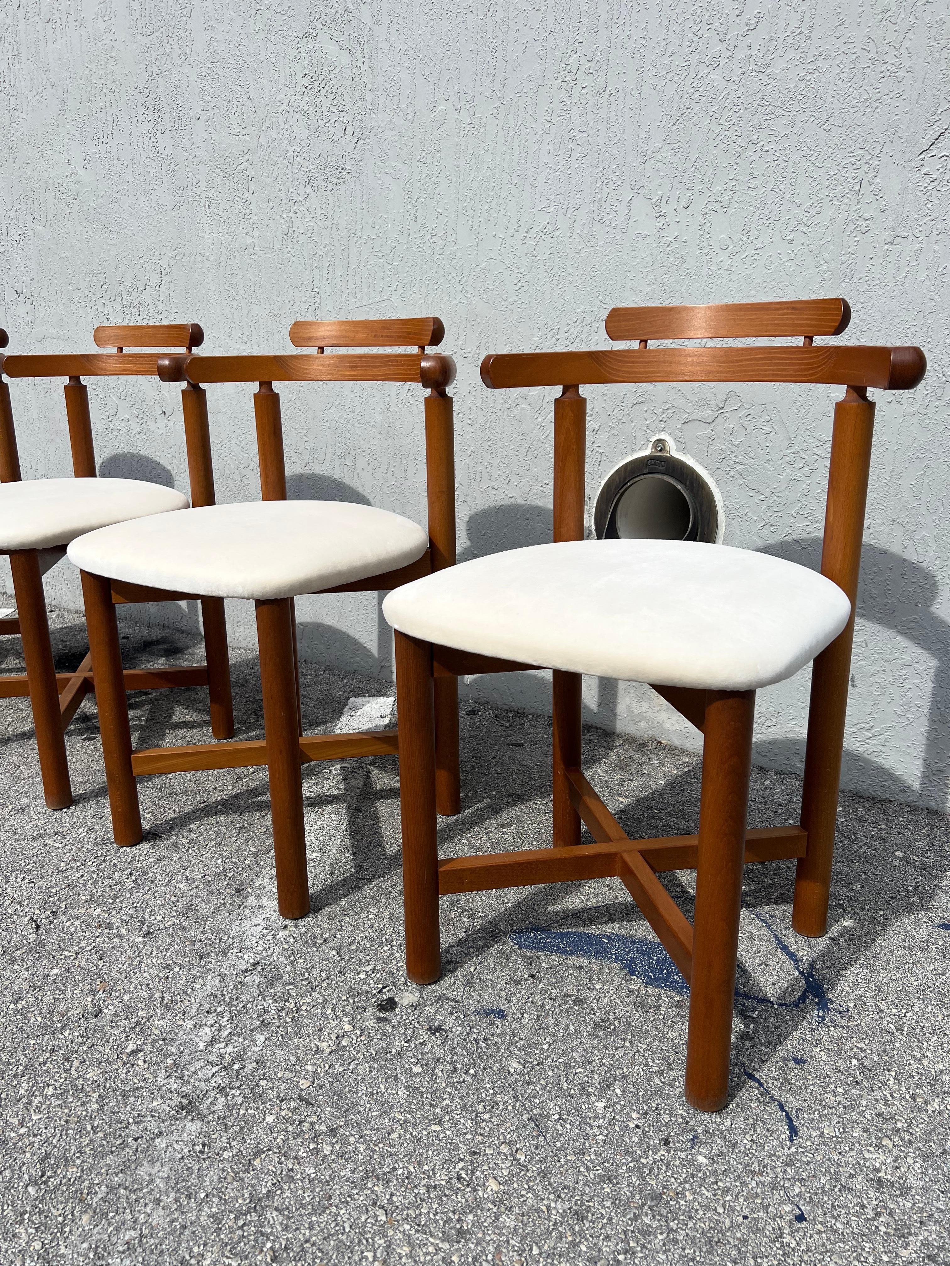 Beautiful teak dining chairs featuring a unique rounded back by Danish company Findhals Møbelfabrik Denmark. These chairs have been newly upholstered in a creamy supple velvet.