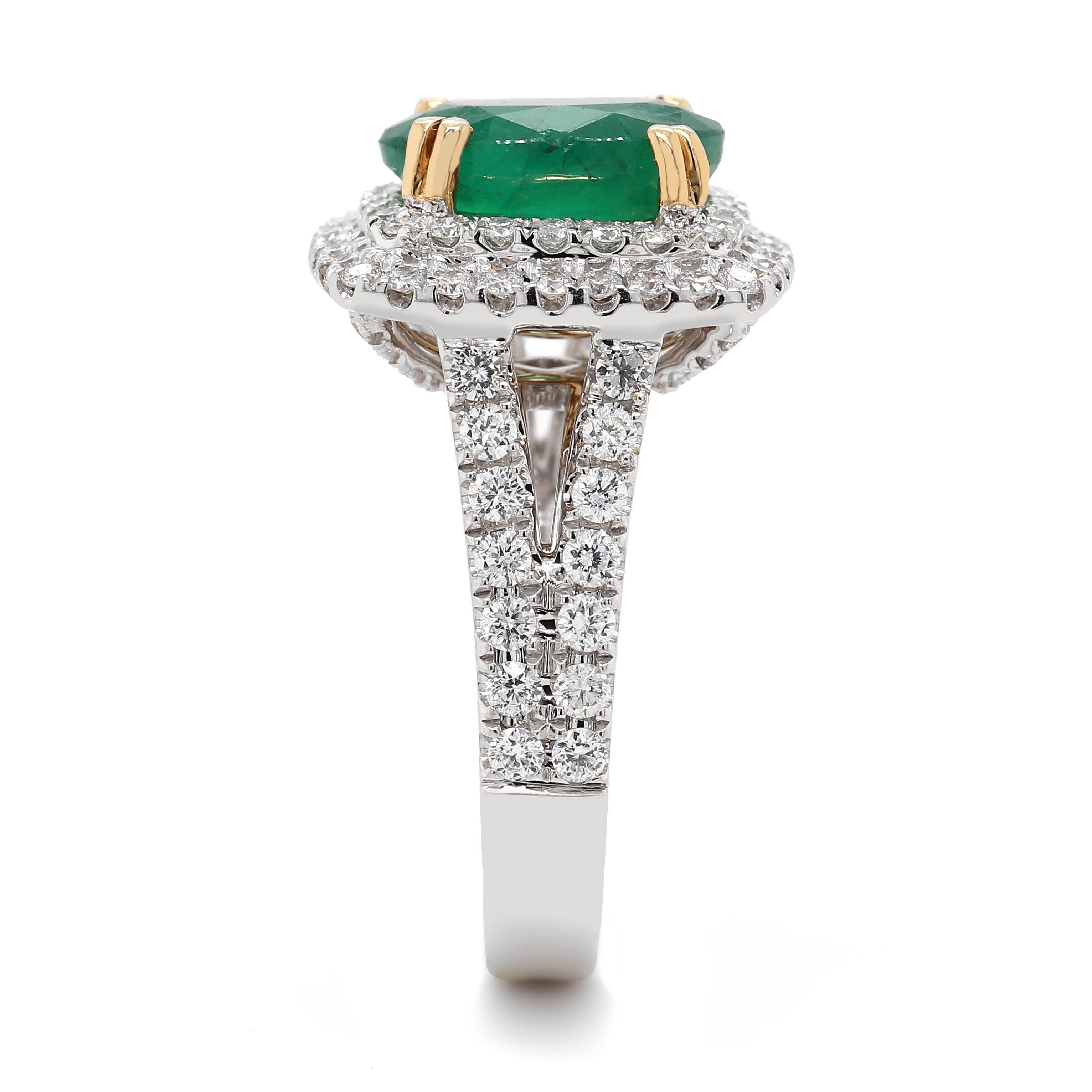 Ring containing one fine oval emerald of about 3.03 carats measuring 8.23×8.41×6.01mm. The emerald is surrounded by 96 round brilliant cut diamonds of about 1.06 carats with a clarity of VS and color G. All stones are set in 18k 2 tone. The total of