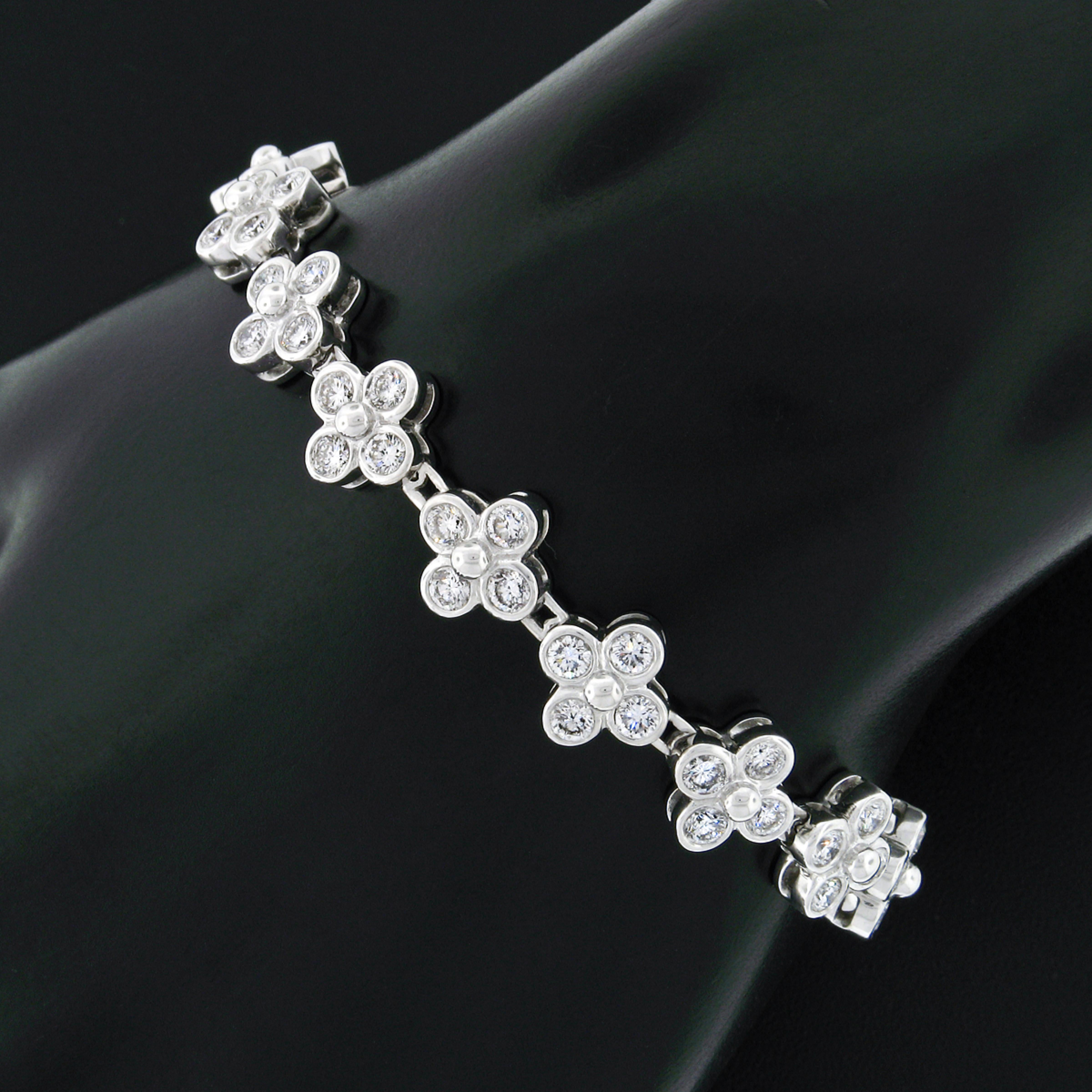 You are looking at a stunning and very well made diamond tennis bracelet crafted in solid 18k white gold and drenched with very fine quality diamonds throughout. The bracelet is constructed from solidly made, quatrefoil design settings that are each