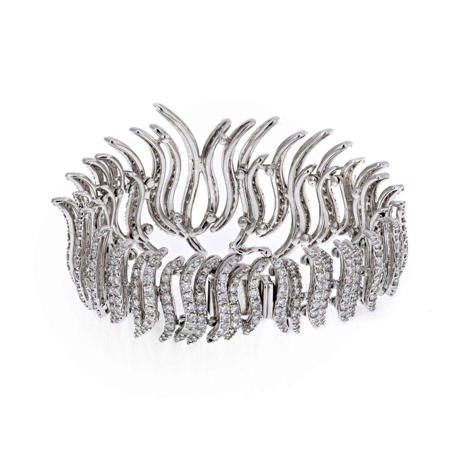 Cet incroyable bracelet de diamants en bandes sculptées est d'une conception et d'un style extrêmement exquis. Cette pièce à couper le souffle est somptueusement conçue en or blanc 18 carats étincelant et ornée de 18 cts de diamants ronds