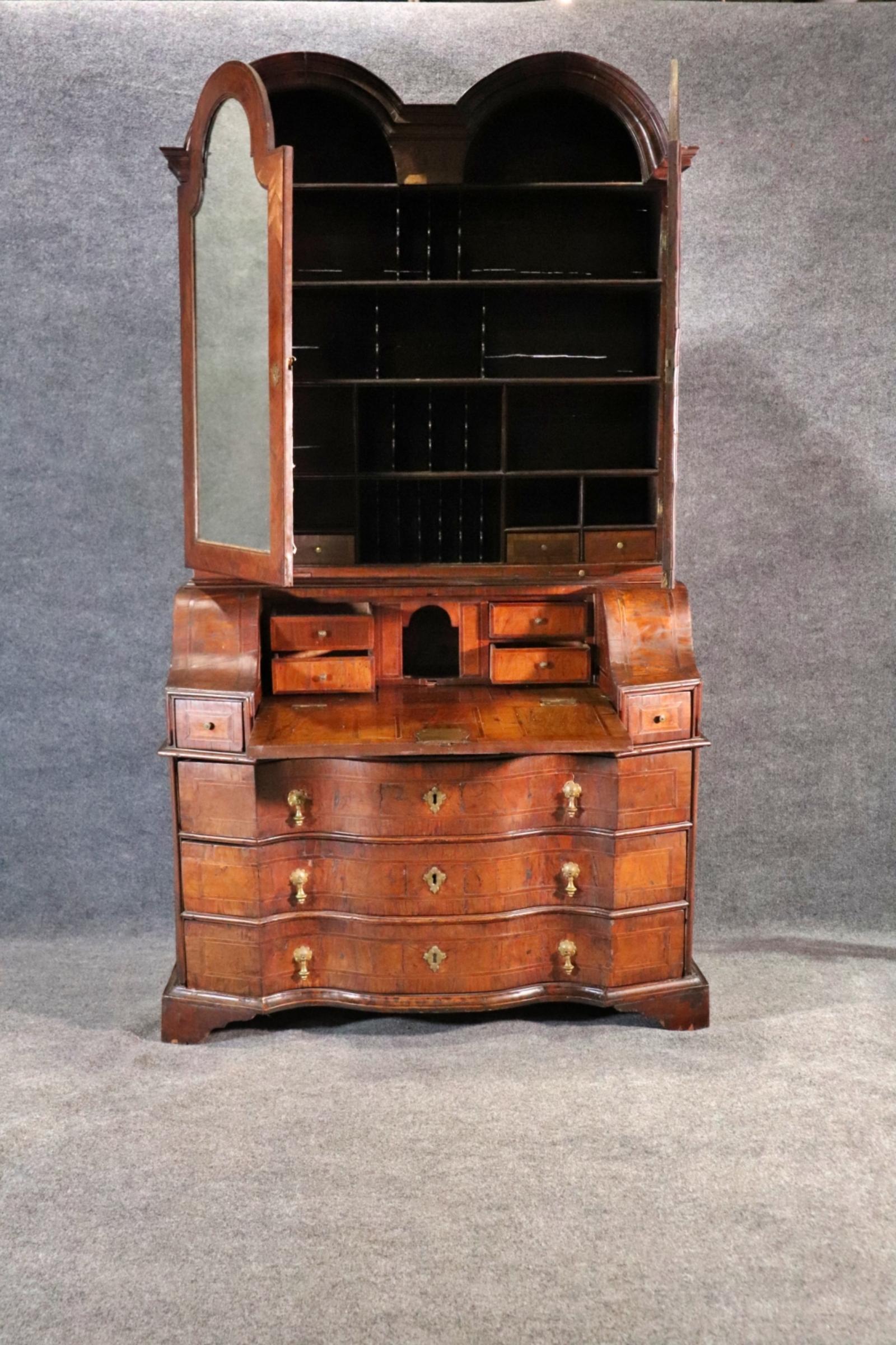 Bureau secrétaire Double Bonnet en noyer anglais. 2 pièces. Il dispose d'un tiroir secret avec un loquet. La partie supérieure comporte 2 portes en miroir contenant un intérieur aménagé. 2 étagères coulissantes. La partie inférieure est munie d'une