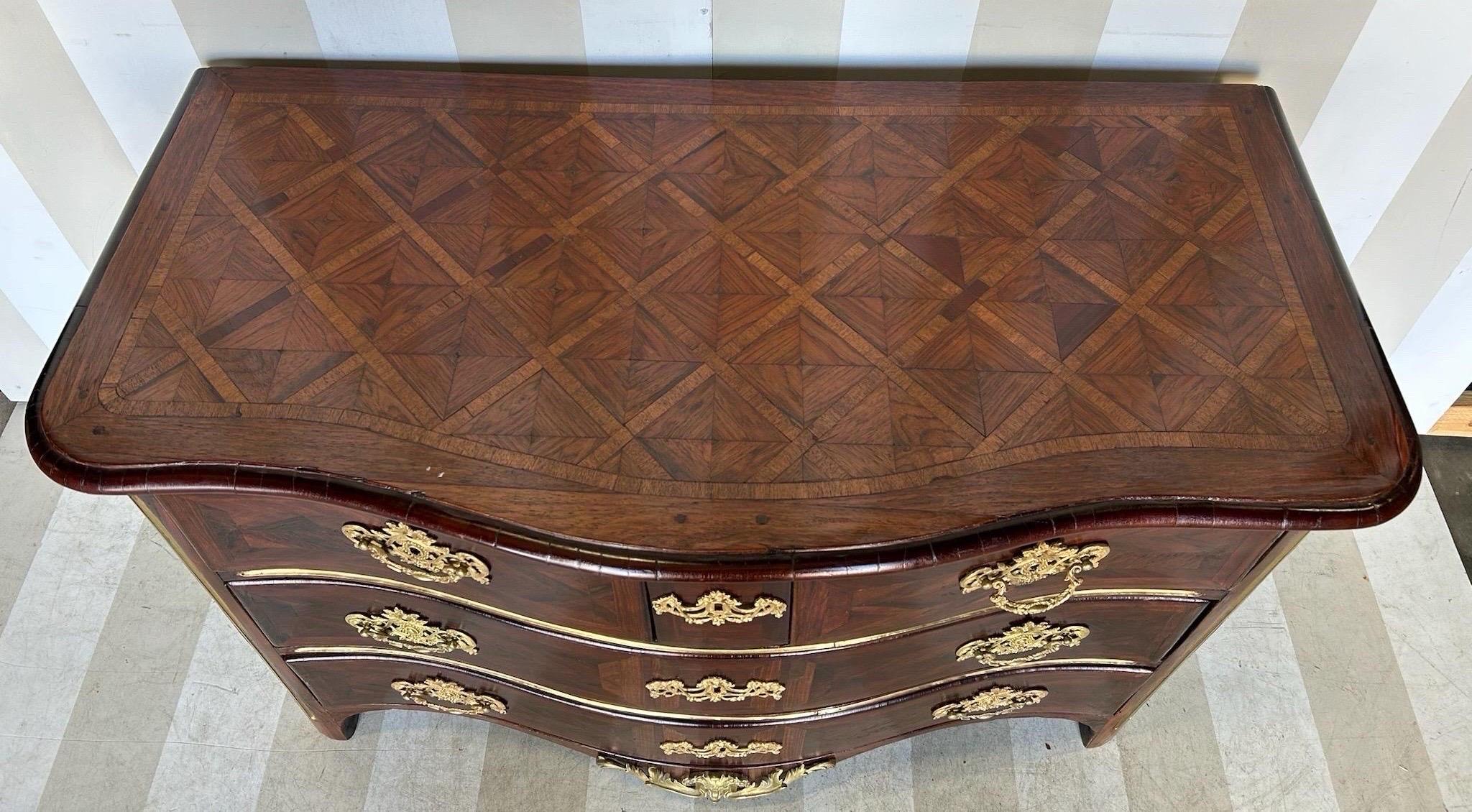 Magnifique commode française du XVIIIe siècle avec dessus en parquet, coins cannelés incrustés de laiton et quincaillerie en bronze doré. 