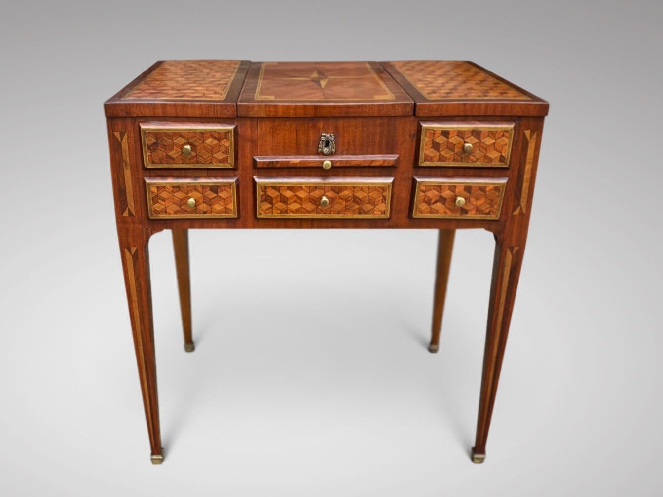 A very fine 18th century Louis XVI Geometrical marquetry dressing table or coiffeuse. The rectangular top divided into three framed parquetry panels, the outer two hinging outwards to reveal box sections, while the central section reveals an