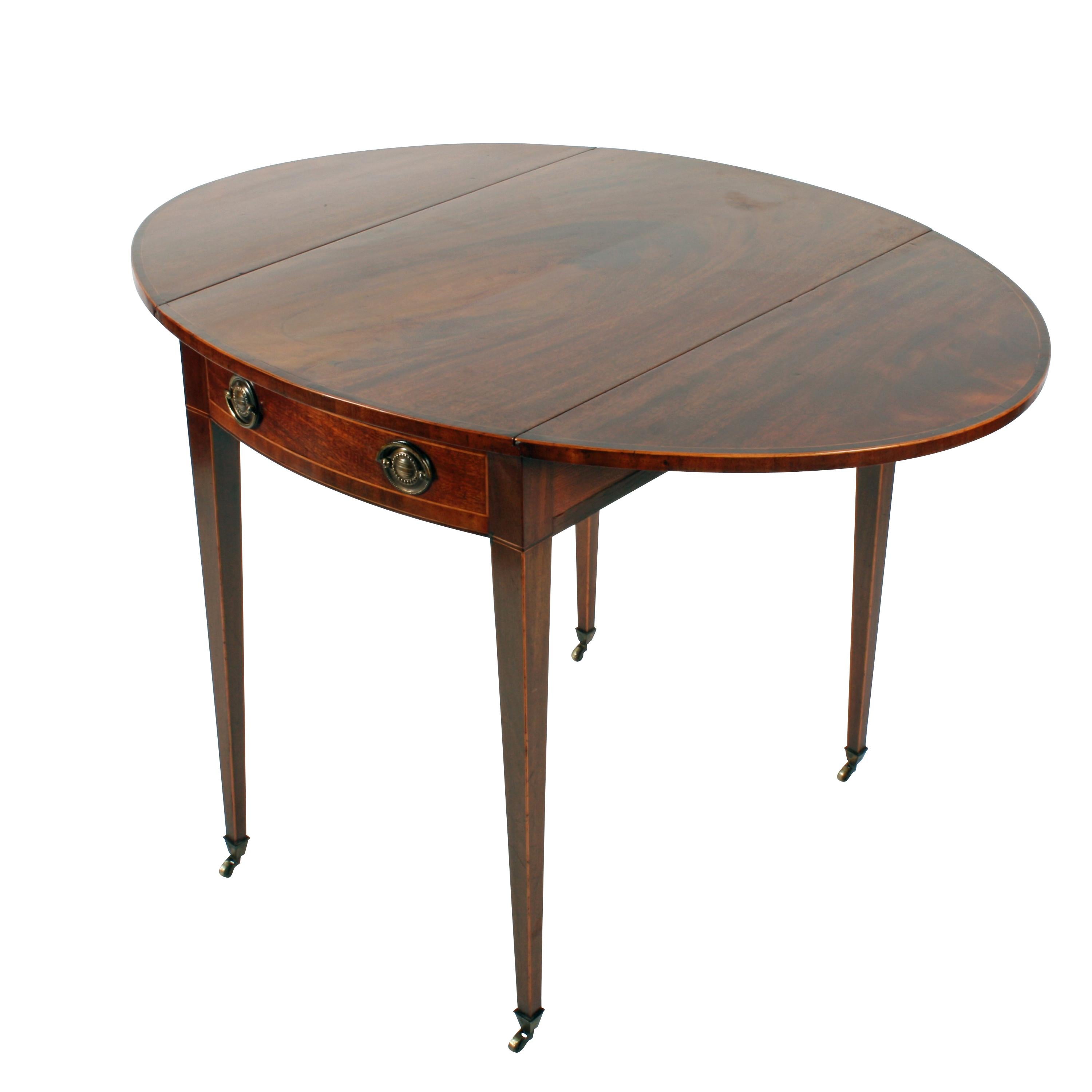A fine late 18th century George III mahogany oval drop leaf Pembroke table.

The table has a cross banded and box wood inlaid top, a box wood edge to the legs, a single drawer and a dummy drawer.

The drawer is oak lined and has a pair of