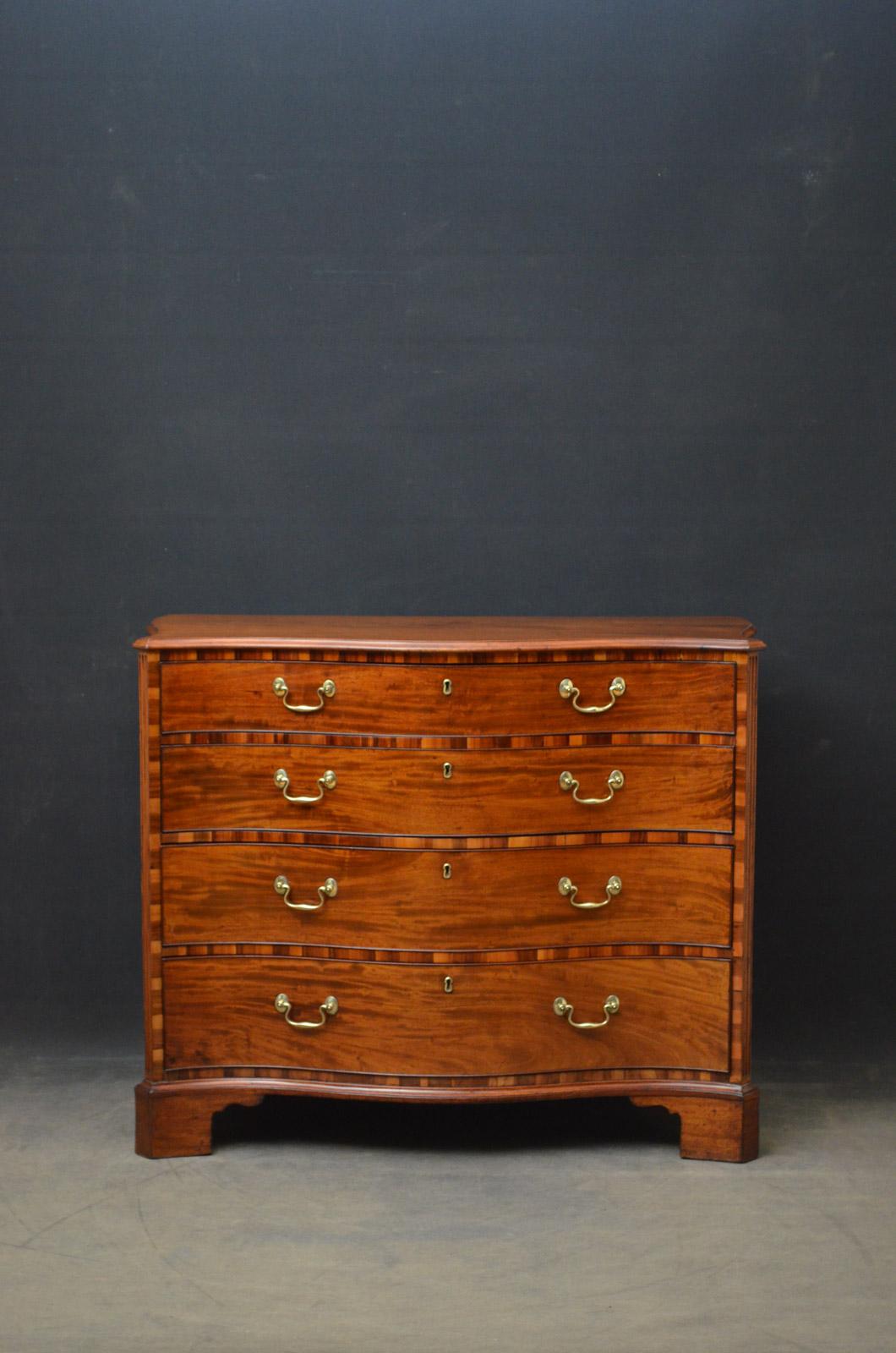 Sn4437, elegant Georgian mahogany chest of drawers of serpentine outline, having figured mahogany top above 4 graduated and cockbeaded drawers all fitted with original brass handles and with gongalo alves decoration between, flanked by reeded canted