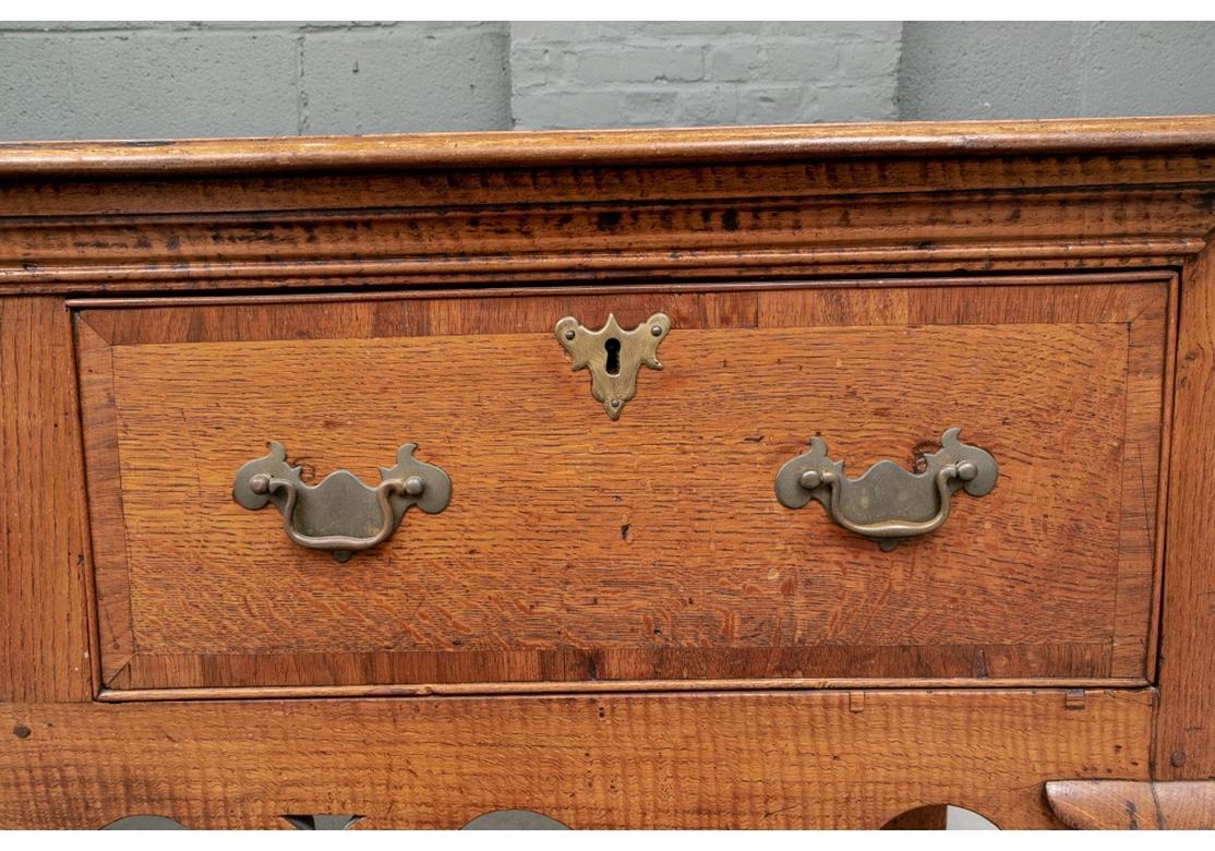 A Rustic and notable 18th Century Welsh Server with fine traditional form and great age and use patina. Constructed of oak, the long dresser with carved top edge (the back few inches have been replaced) over a case with three deep drawers. All with