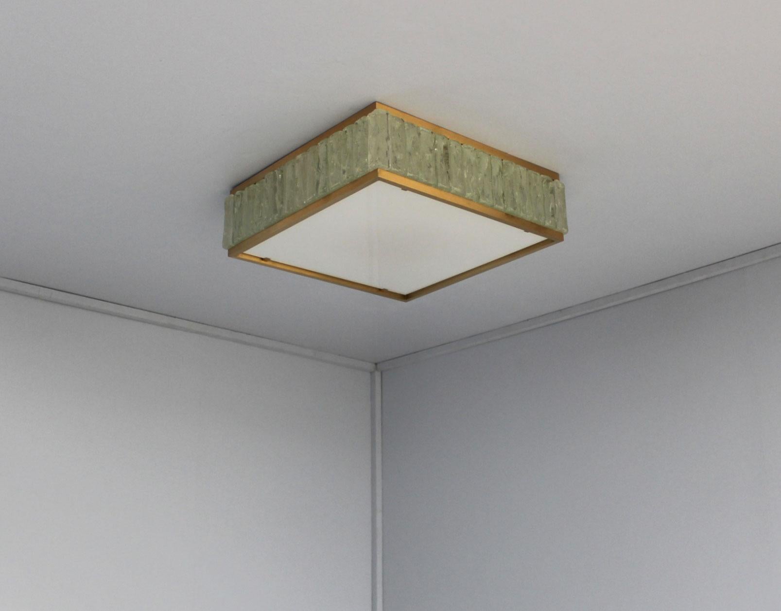 A fine French Mid-Century square “collier de la reine” flush mount by Jean Perzel made with rough laid glass slabs set between two brass frames and a white enameled glass diffuser (which is easy to remove in order to replace the bulbs).
 
  