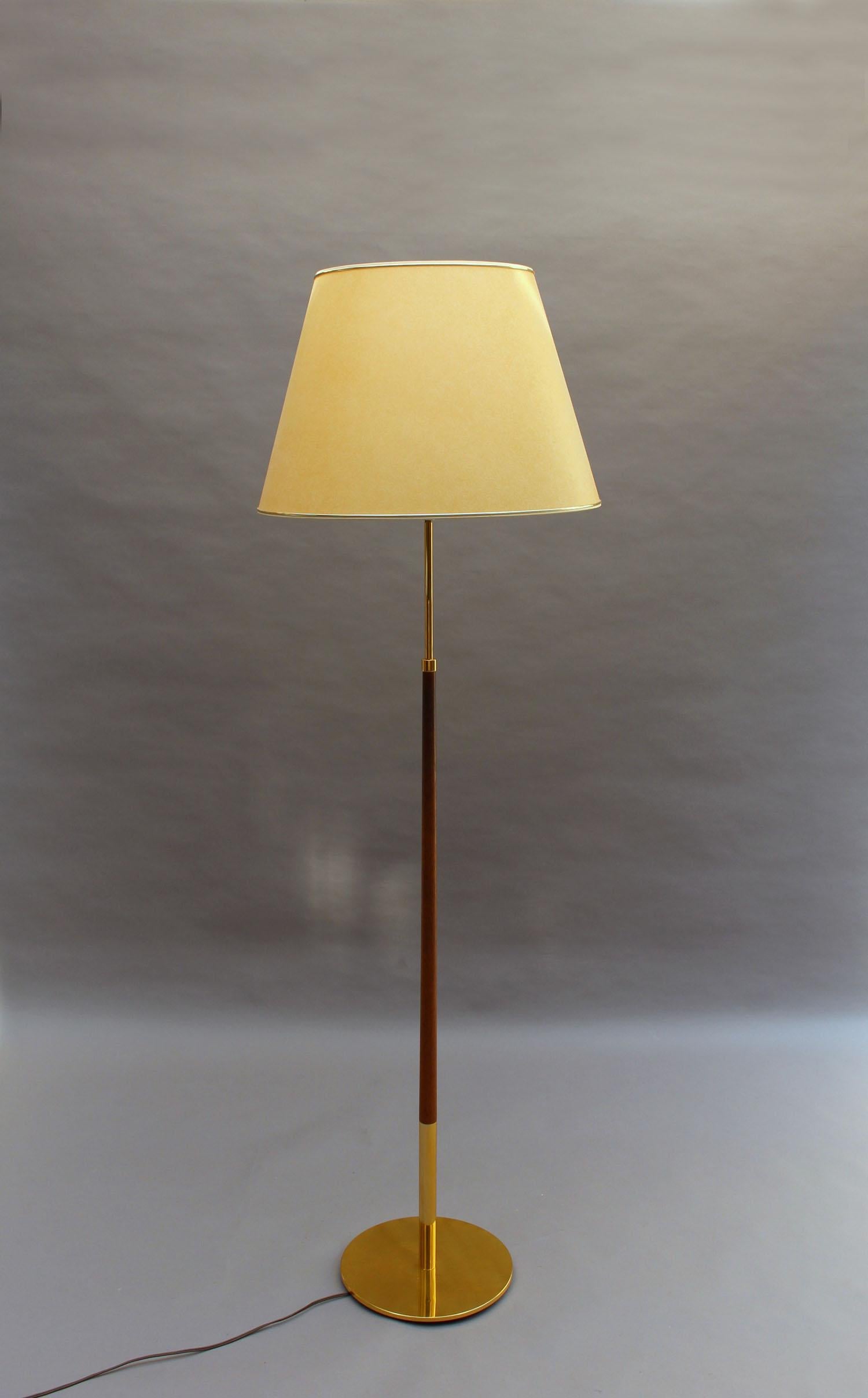Th. Valentiner- A fine mid-century floor lamp with a brass base, and a brass and wooden rod that supports a conical shade.