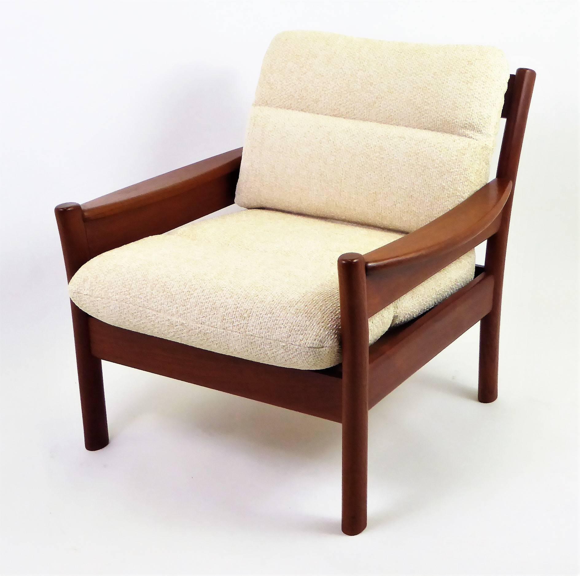 Fine 1960s Dyrlund of Denmark solid teak armchair with fitted cushions in new woven Chenille in a neutral cream color. Warm, rich, solid Teak all around with unique carved legs and wide shaped armrests. Slatted back. Dyrlund label. New Pirelli
