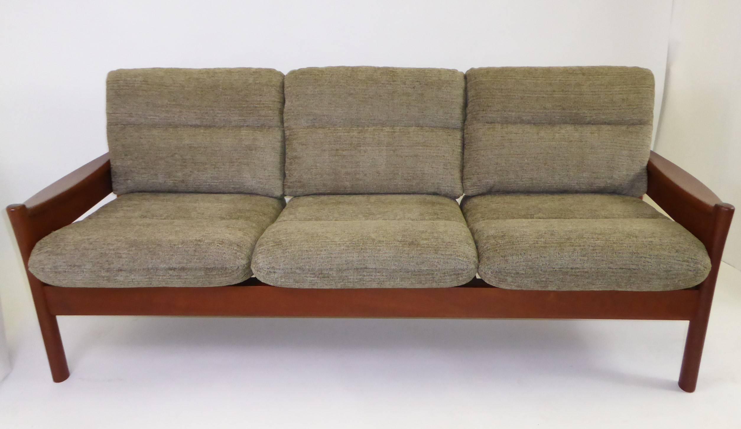 Fine 1960s Dyrlund of Denmark solid teak sofa with fitted cushions in new woven Chenille fabric in a olive green color. Warm, rich, solid Teak all around with unique carved legs and wide shaped armrests. Slatted back. Stylistically, very much like