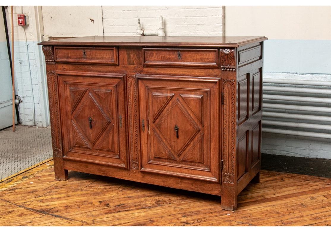 A fine authentic European (Probably French) cabinet with nice carved details. Mortise and tenon construction with a banded top and two frieze drawers (with a key). The side supports and center frame with carved leaves. Carved double doors in diamond