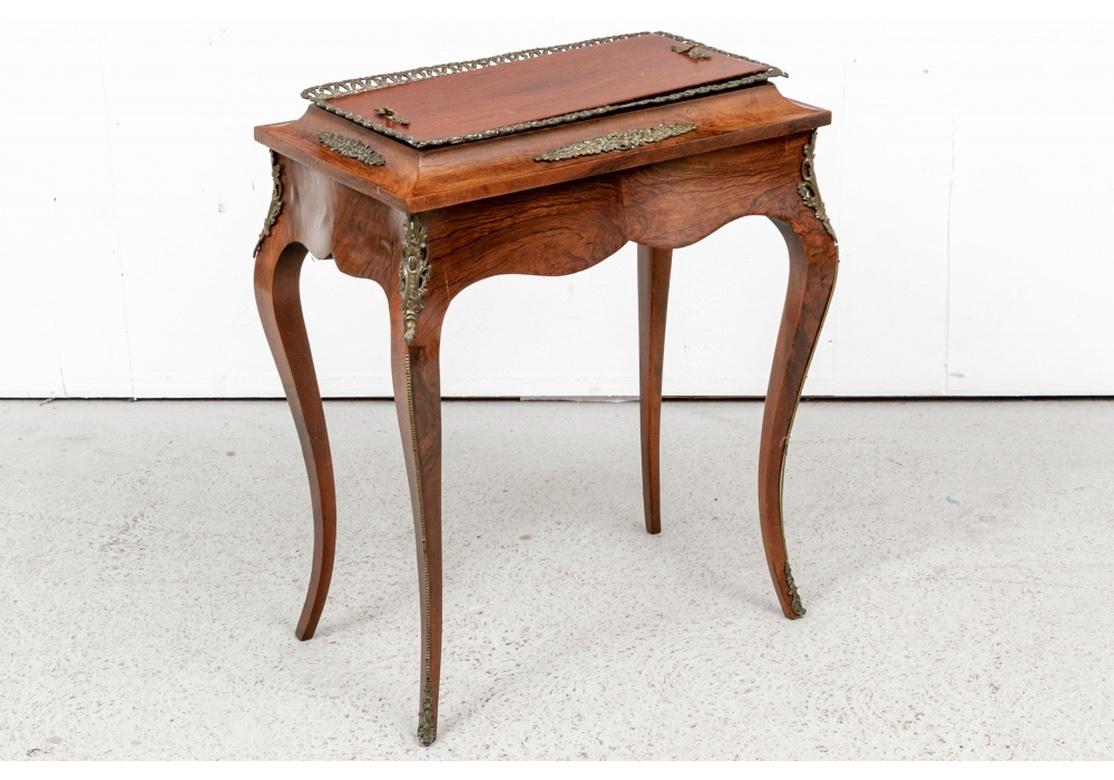 A rarely seen planter stand, finely made with particularly handsome graining. Louis XVI style with a shaped book matched figured frieze. The raised top with brass rope motif border, floral mounts on all sides, and lid with twin handles. No lining in