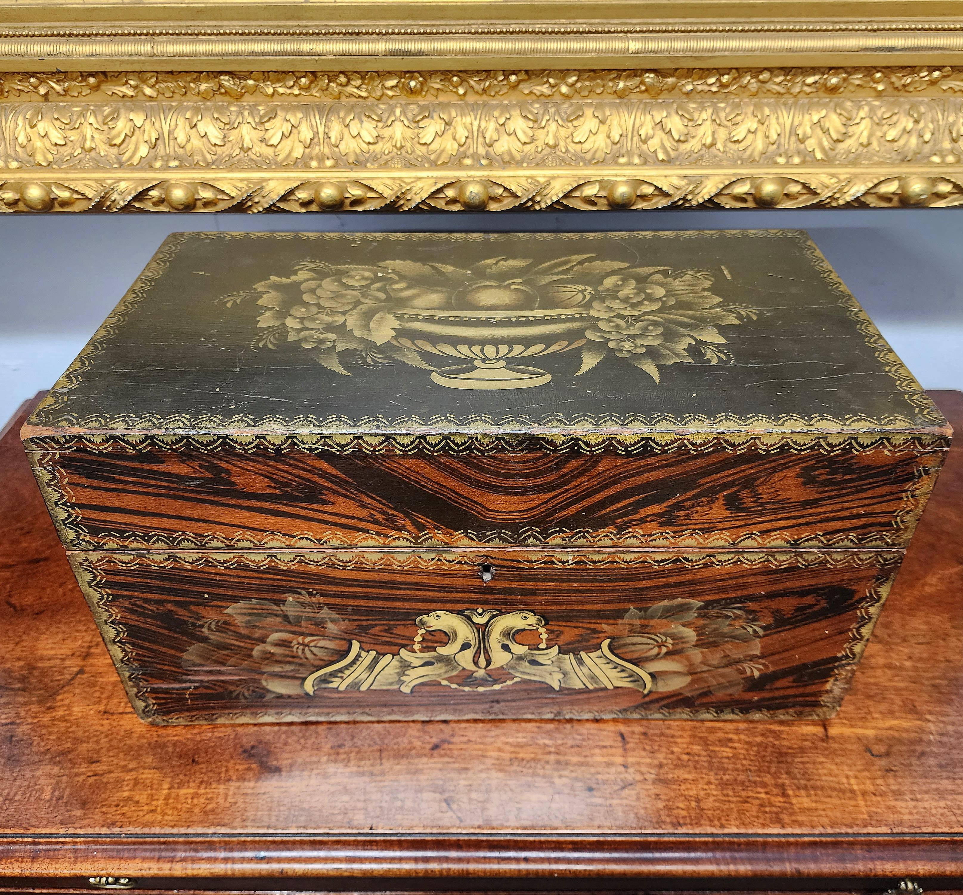 A spectacular and fine, dovetailed poplar, rosewood grain painted and ebonized document box. The gold stenciling is of a very fine quality. Retains the original fire gilded steel bails and finish. A fine federal form. New York circa 1815. 
     