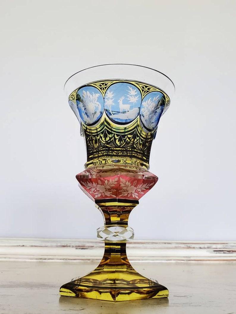 A magnificent piece of Bohemian art glass from the first half of the 19th century. The exceptionally executed antique colorless with amber, cobalt and ruby flash, having a tapered bowl with vignettes showing flowers, ivy, stag deer and hunting dog,