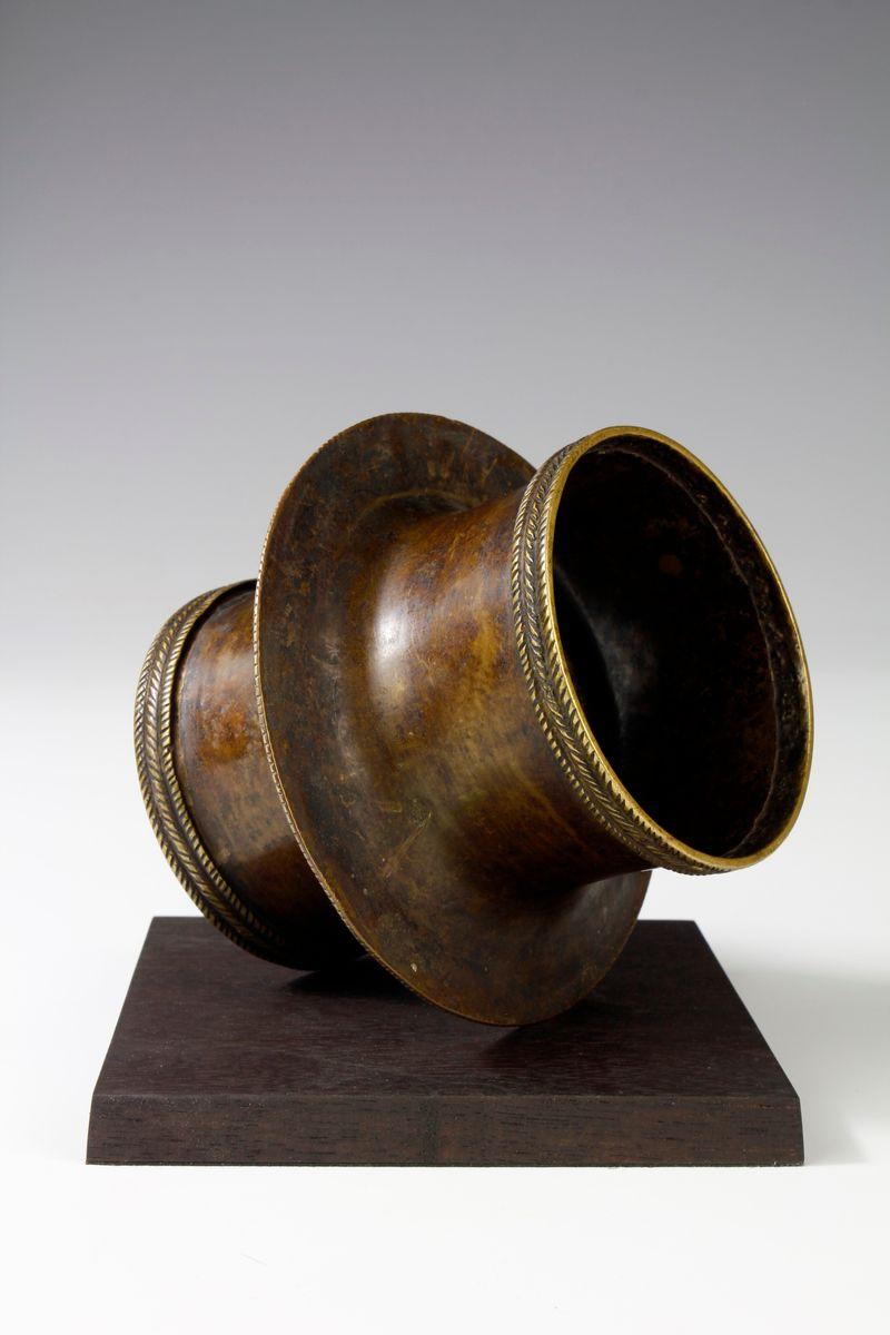 Este adorno de brazo de bronce finamente fundido de finales del siglo XIX, procedente de Camerún, es posiblemente de origen kirdi. El adorno, que muestra una bella forma, presenta una prominente cresta central y, con el paso del tiempo, la