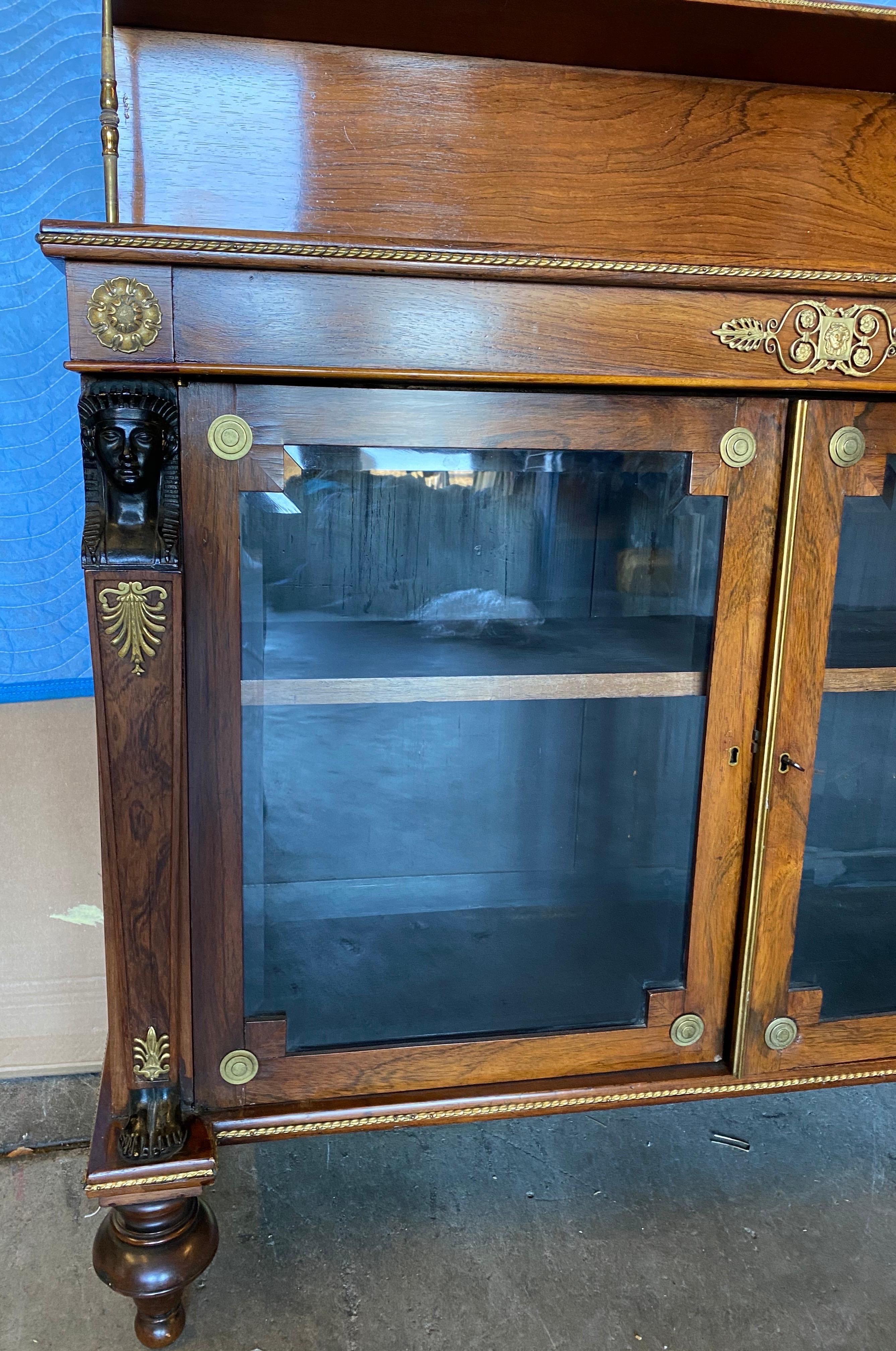 Fine 19th century English Regency bronze mounted rosewood chiffonier. Great quality bronze mounts and caryatids forming the stiles. Beveled glass doors and handsome turned feet.