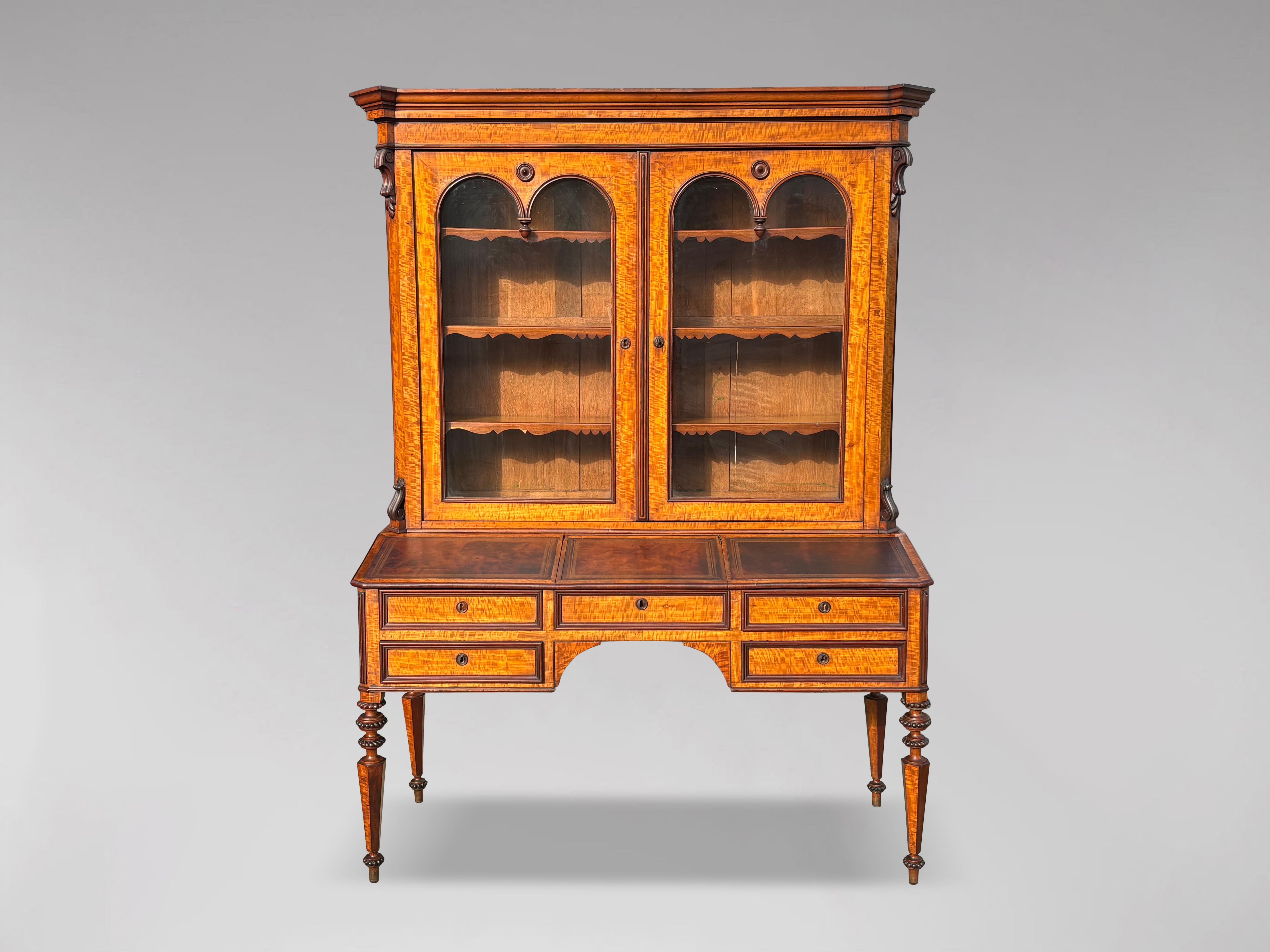 A fine 19th century French Louis-Philippe period maple & mahogany bureau bookcase. Shaped moulded sides and cornice above a pair of shaped glazed doors with adjustable shelves, above a bureau section with three leather tooled sets, above the