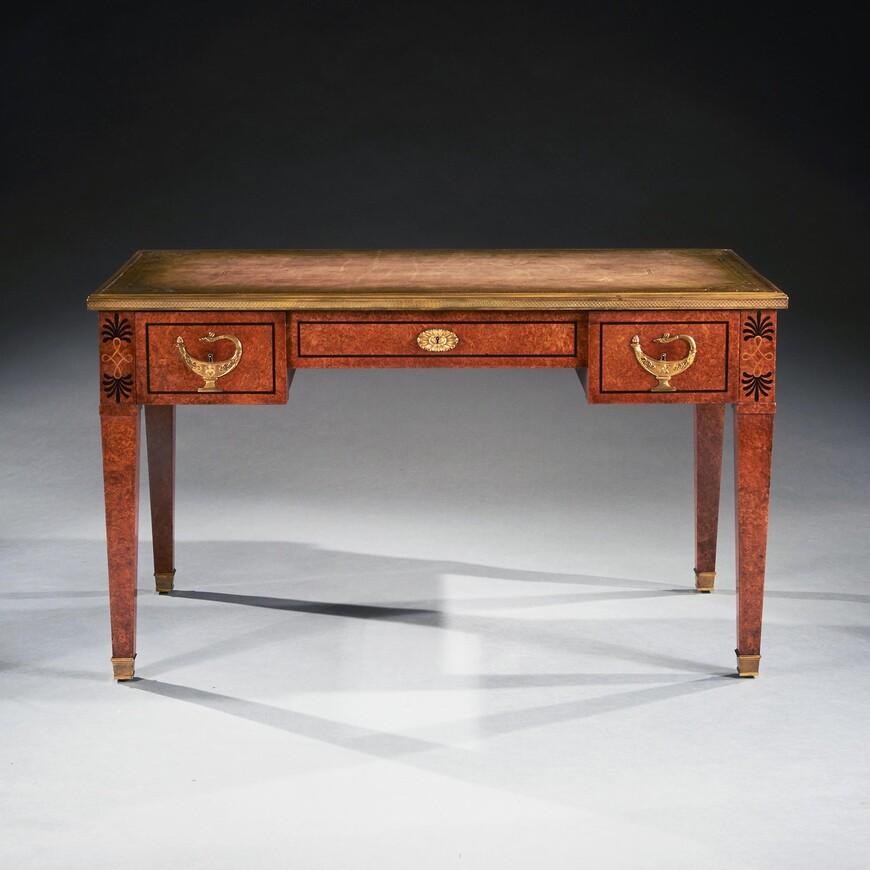 An extremely fine and unusual French Amboyan and gilt bronze bureau plat - writing table inspired by the Neoclassical designs.

French circa 1880-1900.

A superb amboyna writing desk having distinctive ormolu mounts to the frieze shares some of