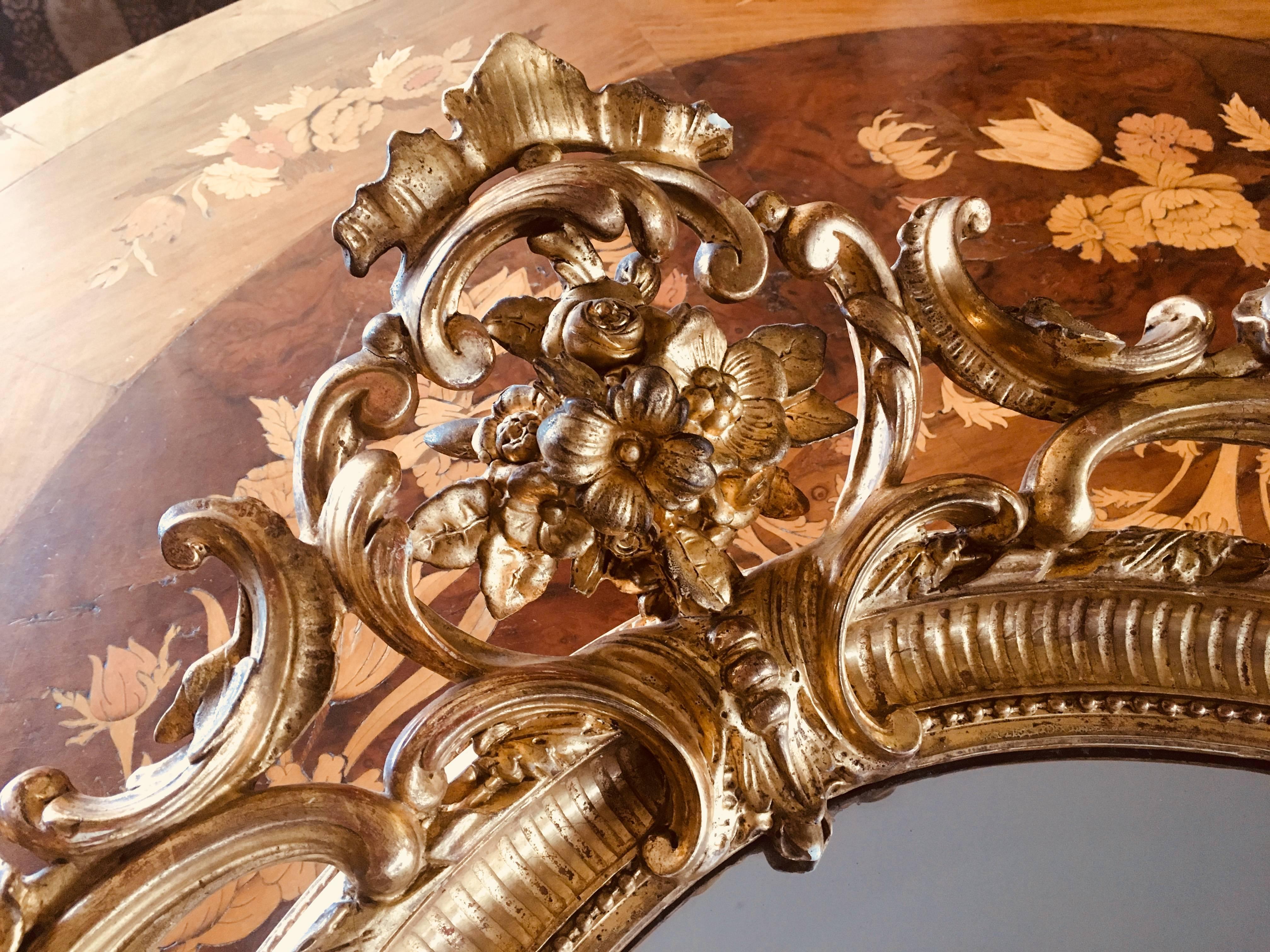 19th century oval mirror of Napoleon III period. Carved wood, covered with gesso and 24-karat gold leaf finish. This piece has beautiful ornaments and it wears its original glass,
France, 1860.