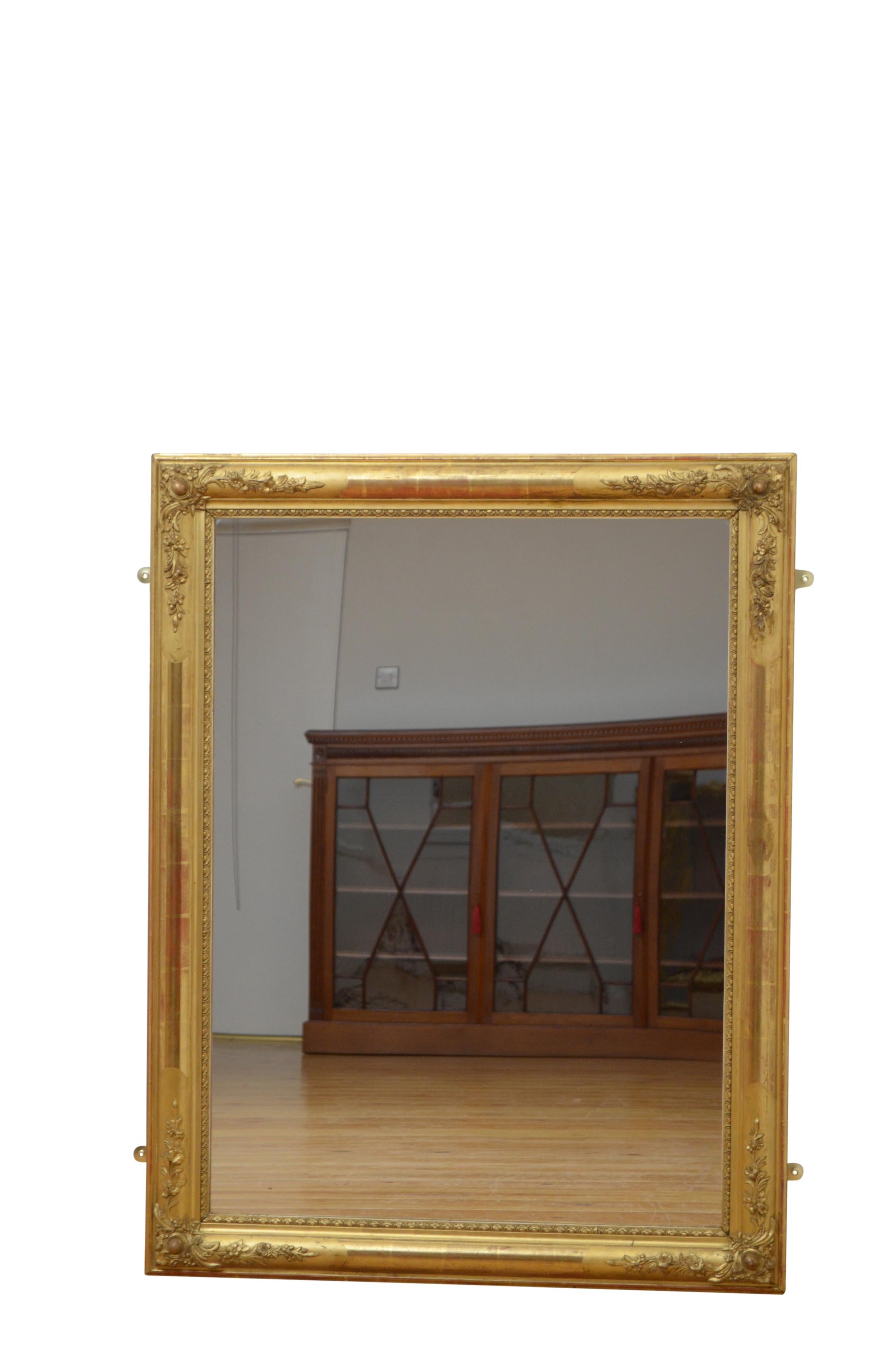 Very attractive giltwood wall mirror of versatile form, it can be hung horizontal or vertical way, having replacement glass in moulded and gilded frame with floral decorated corners. This antique mirror retains original gilt with replacement back.