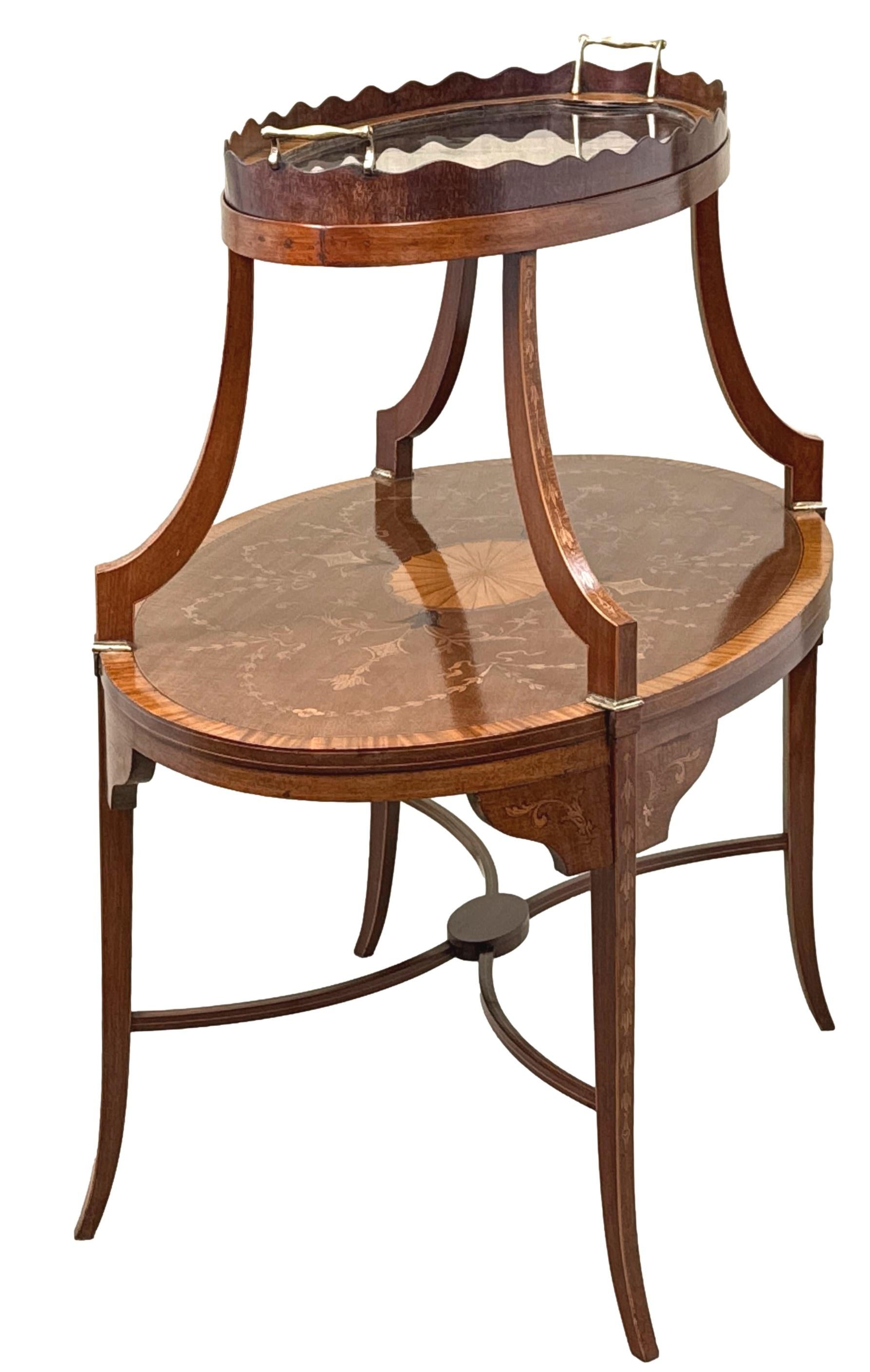 Très belle qualité d'acajou et de bois satiné de la fin du XIXe siècle pour une étagère ovale à deux niveaux, un serveur muet ou une table d'appoint, avec un plateau en verre amovible à bord ondulé et galonné sur le dessus, reposant sur des supports