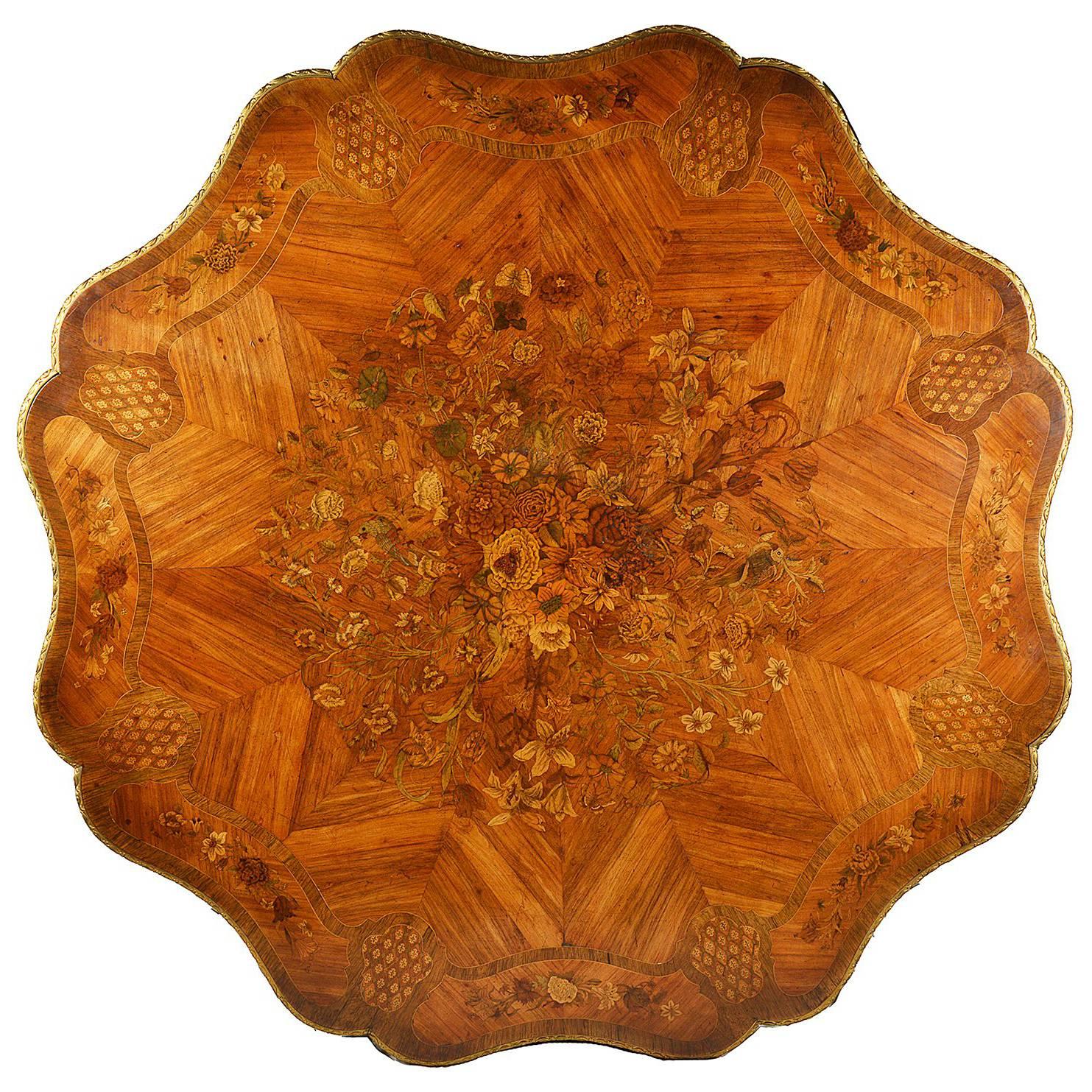 This wonderful quality 19th century marquetry inlaid table, having birds, flowers, foliage and butterflies in the centre, radiating veneers, the cross banding having panels of flowers and motifs. Drawers to the frieze, raised on four scrolling