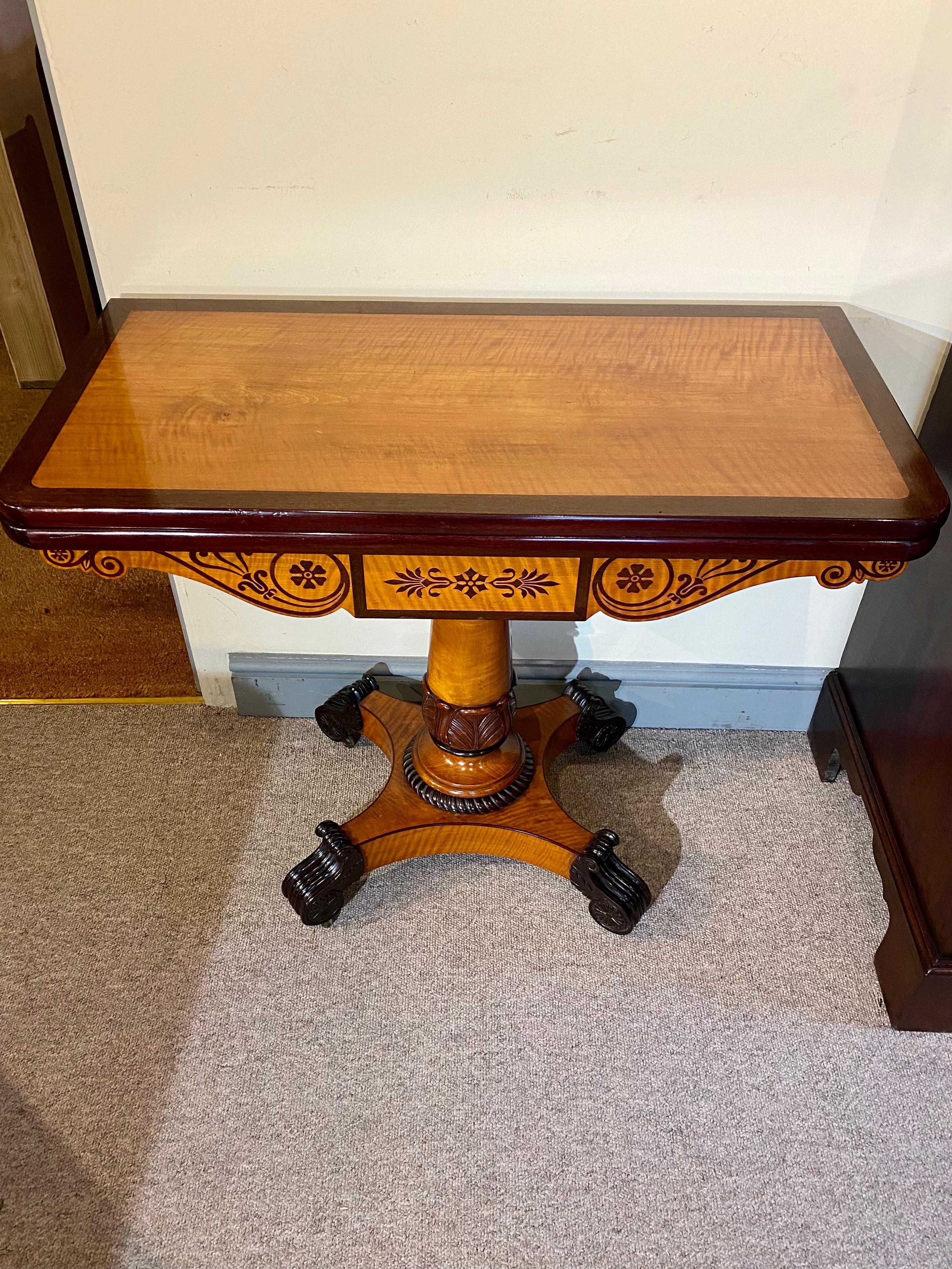 An exceptional Regency period Satinwood, Ebony and Purple Heart Tea Table. At the front of the table the beautifully figured satinwood top is upheld by shaped satinwood supports which are masterfully inlaid with Purple Heart, a very desirable