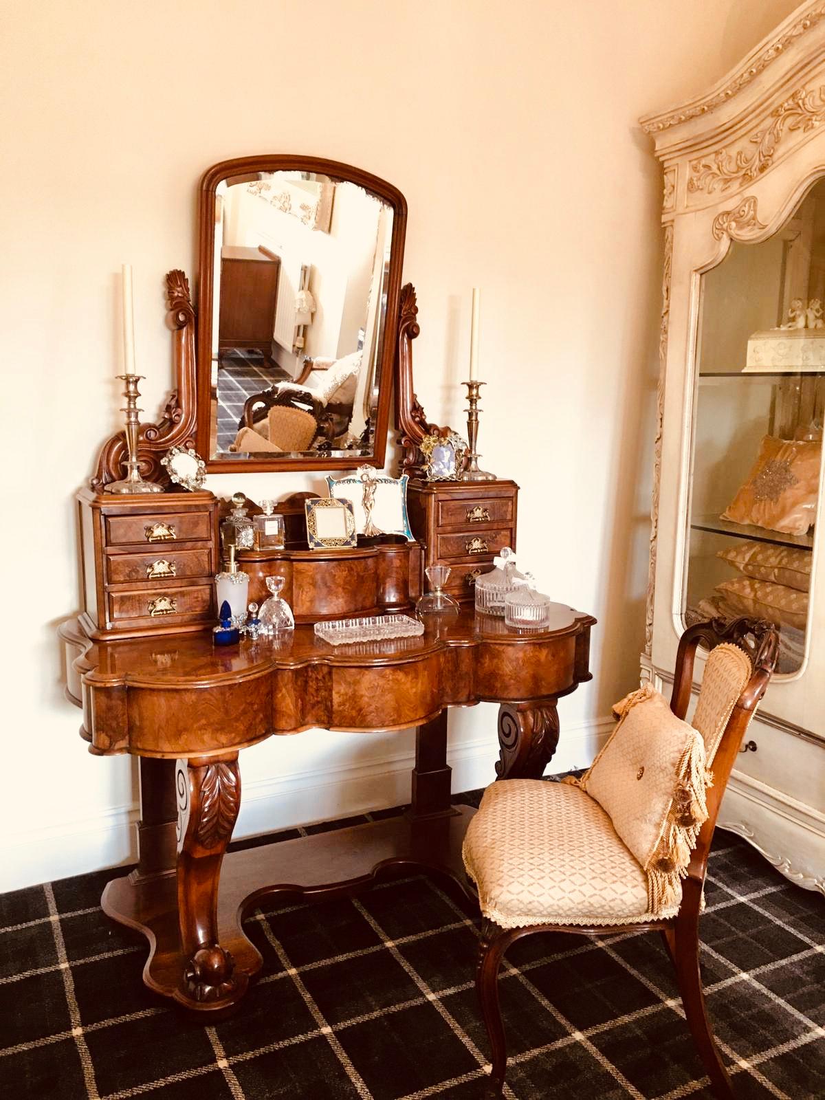 A fine 19th century Victorian Antique burr walnut dressing table having a beautiful shaped tilting mirror to the top section supported by two carved walnut arms above six elegant burr walnut drawers with original brass handles. It boasts a shaped