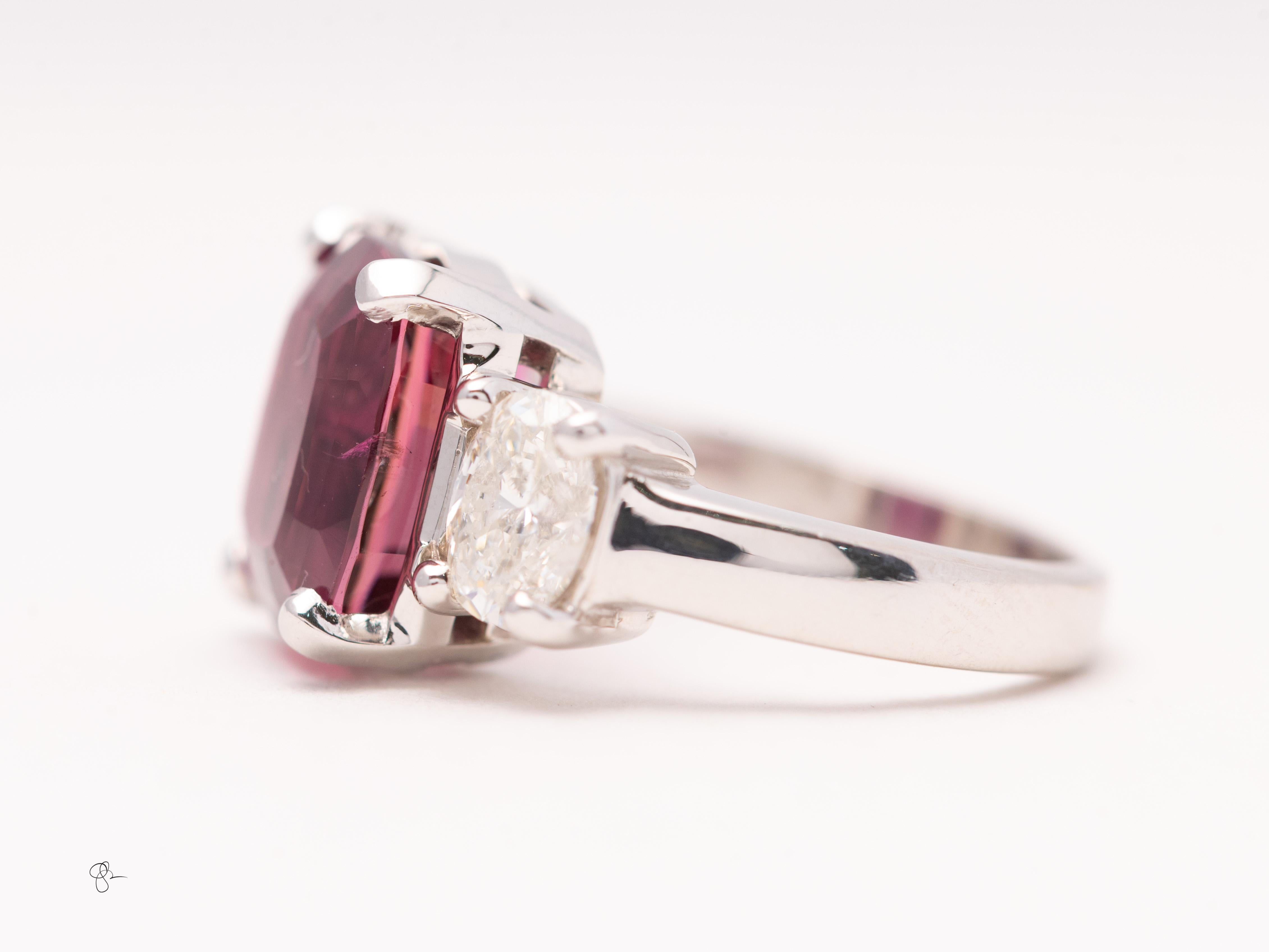 Tourmaline rose fine 6,27 carats
Deux pierres latérales ovales 1.18  carats de diamant, poids total.
Façonné dans 11,9 grans de platine.

Cette exquise bague en platine à trois pierres met en valeur une tourmaline rose de taille coussin, d'un poids