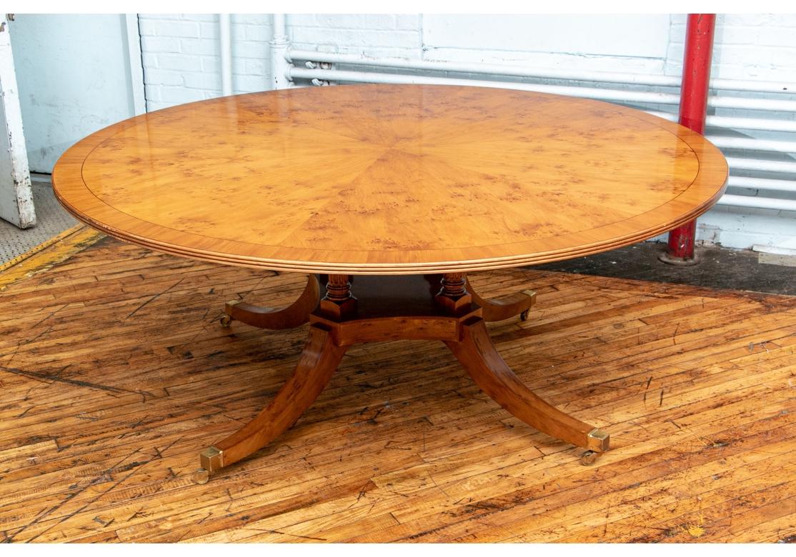 Une élégante et grande table de salle à manger ronde avec un plateau assorti à un livre et un plateau à bandes avec un bord en roseau. Cage à oiseaux classique reposant sur quatre colonnes cannelées et une base incurvée avec quatre pieds évasés à