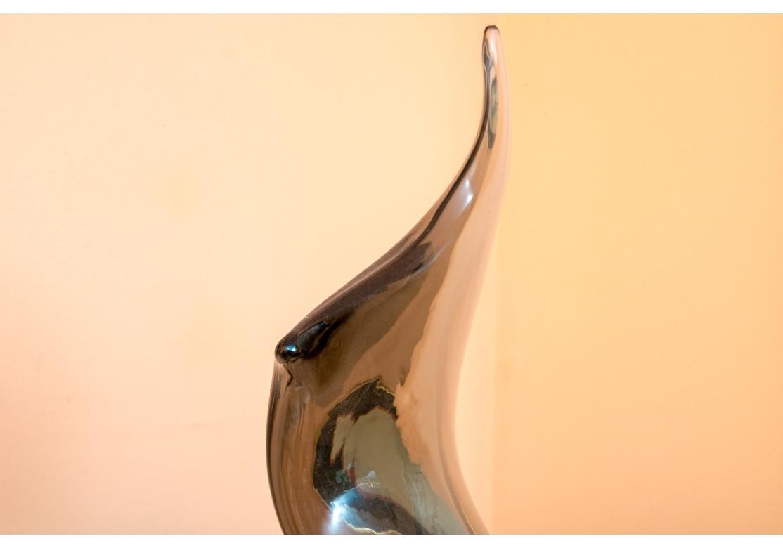 Fine and very well crafted Abstract Glass Sculpture mounted on a custom marble base. The sculpture is in an uplifting and sensuous curving form with fine balance, movement  and poise. The sculpture is mounted on a Minimalist illuminated black column