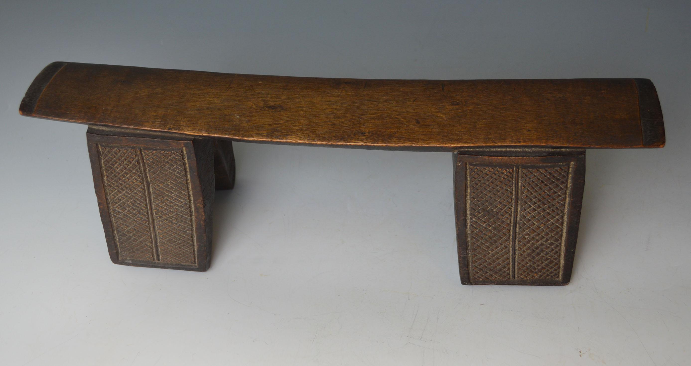 A fine Zulu head rest South Africa,
A fine large Zulu hard wood neck rest,
This Zulu neck rest is carved from a single piece of very hard wood with two fluted legs on each size and convex under section.
Collected by Charles Neilds of Manchester