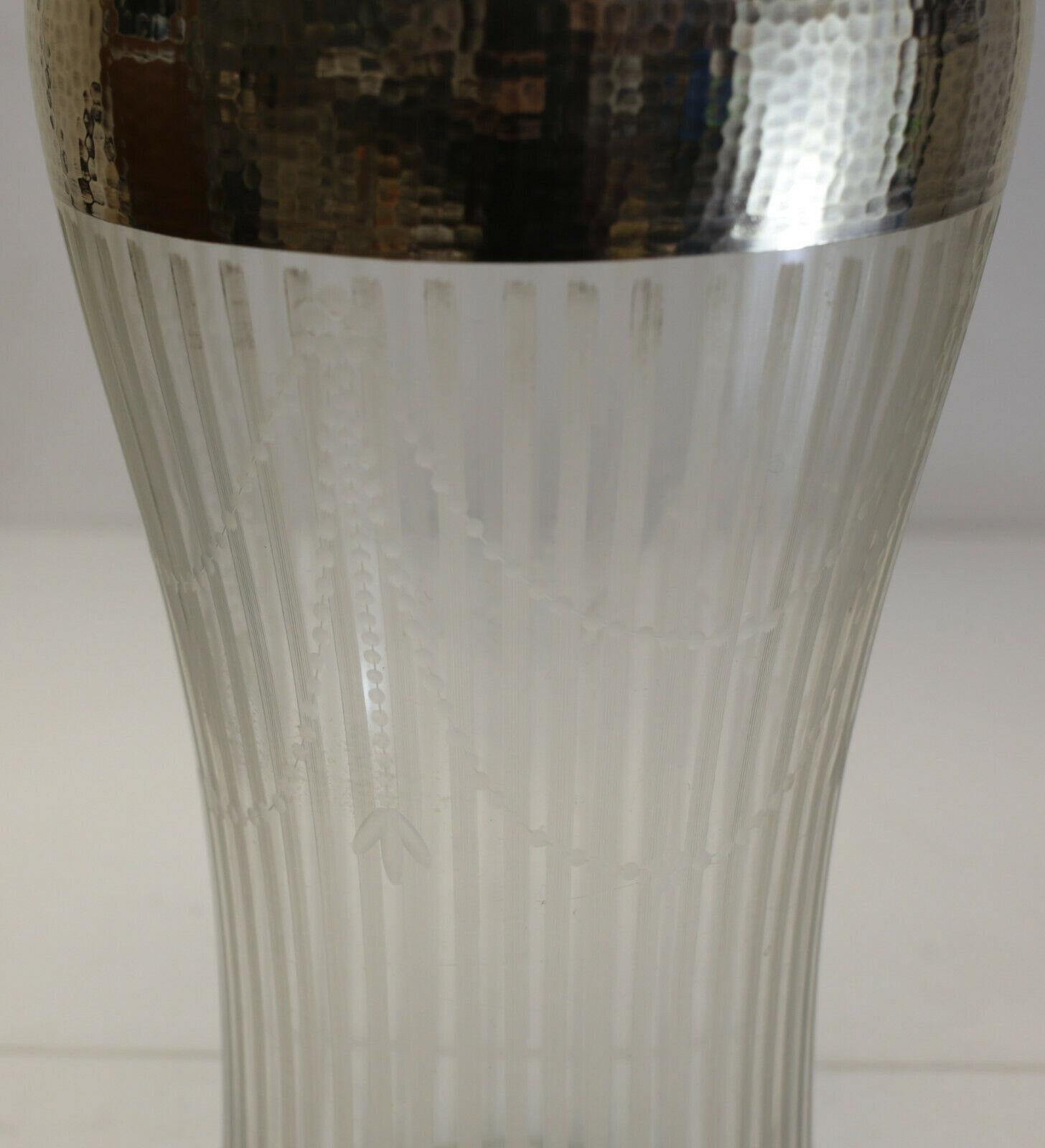 Fine American sterling silver overlay cut glass vase, circa 1900.

Etched stripes throughout the vase with laurel swags to the exterior of the vase. Unusual hand hammered silver overlay towards the top rim. Marked sterling. Cut pontil to the