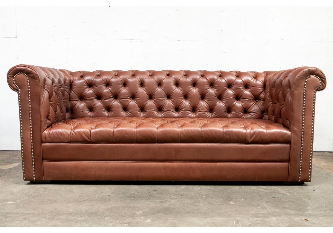 The Classic Chesterfied style in a glove soft Brown Leather. The Sofa is firm but quite comfortable and features the iconic rolled arm, brass nail-head trim and overall tufting. Very well made. 

The Chesterfield measures 89.5” wide by 37” deep by