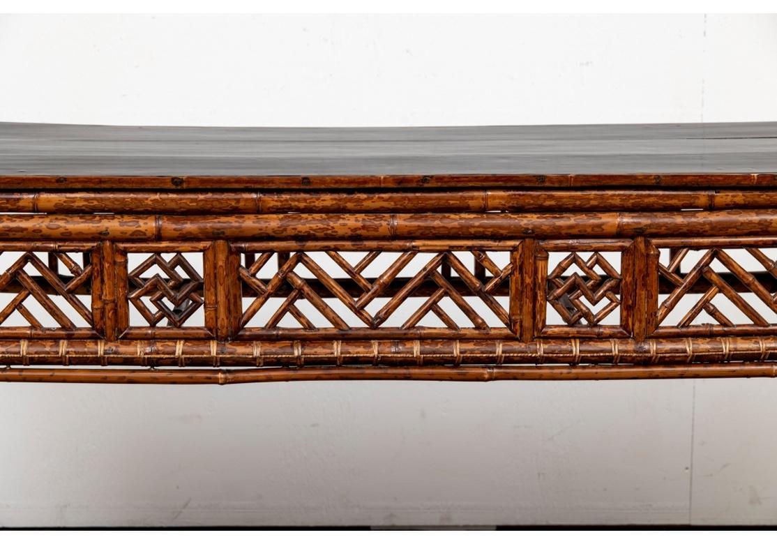A very fine and intricately constructed Bamboo Console Table with all-over cross-hatched and Chevron worked Bamboo decoration. The Bamboo itself has handsome figuring and great color The top in a Black Lacquer with a pleasing polished finish.
