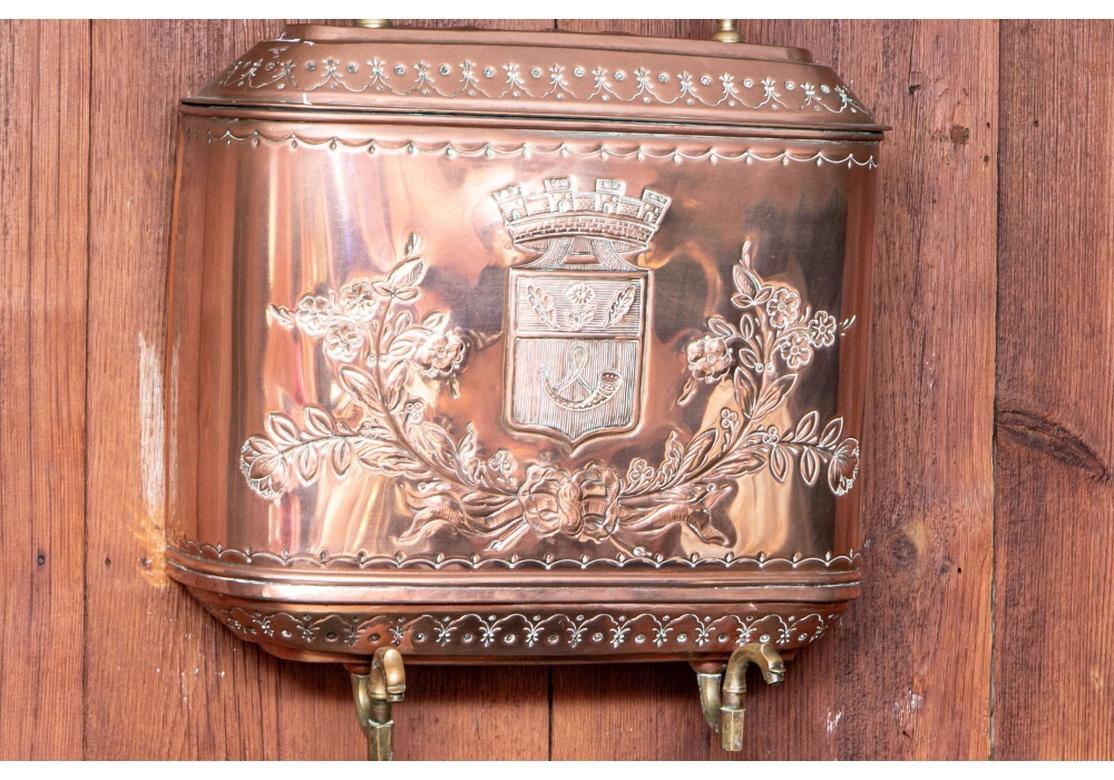 French repoussé copper lavabo has an elaborate coat of arms on the front of the upper storage tank where the water is held. A bronze spigot allowed the water to empty into the bottom basin by turning it to the right or left. The lower basin has