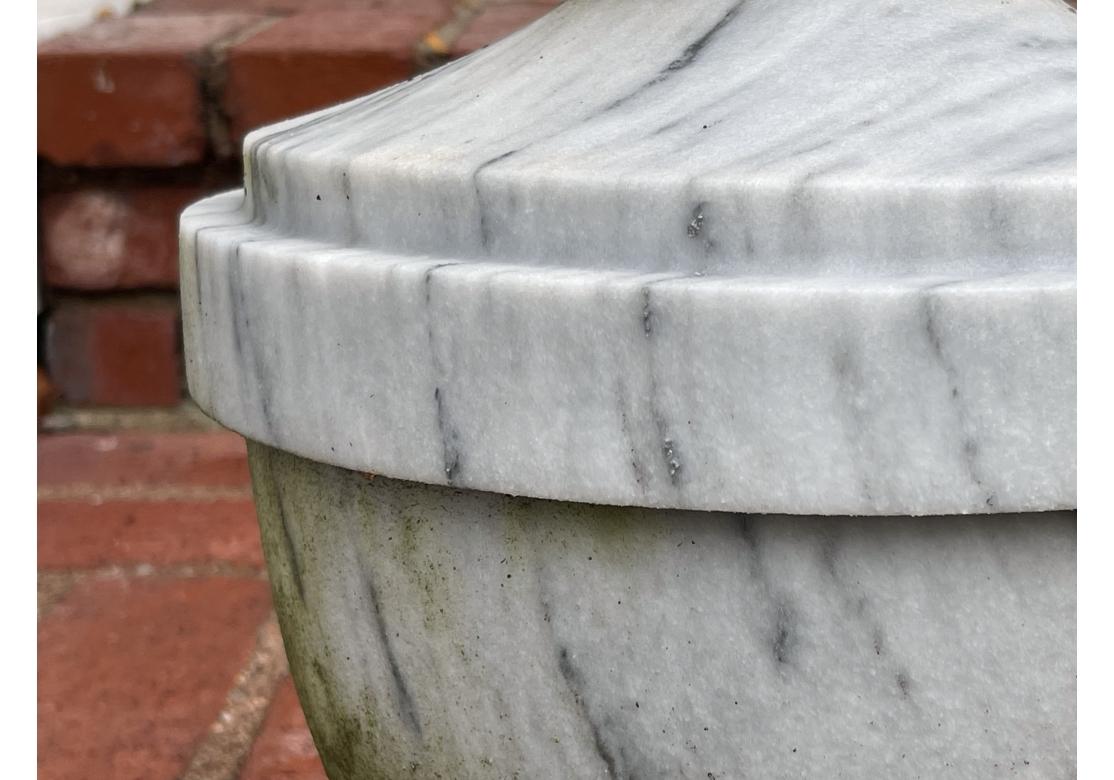 Grande urne de jardin en marbre sculpté, blanc strié avec des stries anthracite. En deux parties avec une base en escalier. Forme traditionnelle d'urne avec faux couvercle et fleuron en forme de gland stylisé

Dimensions : 8,25
