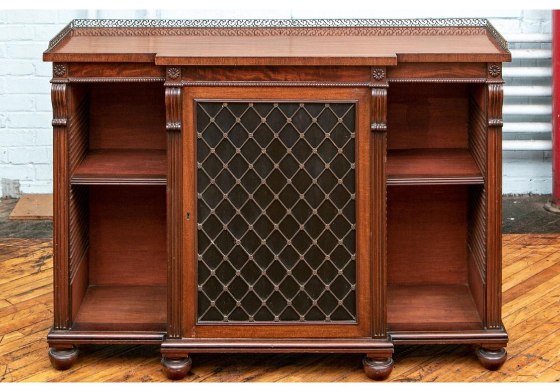 Monumental pair of English mahogany bookcase cabinets with grid doors, adjustable side shelves, beading accents, bun feet and brass galleries.
The central portion on each bookcase houses two adjustable shelves.
The pair have stately proportions as