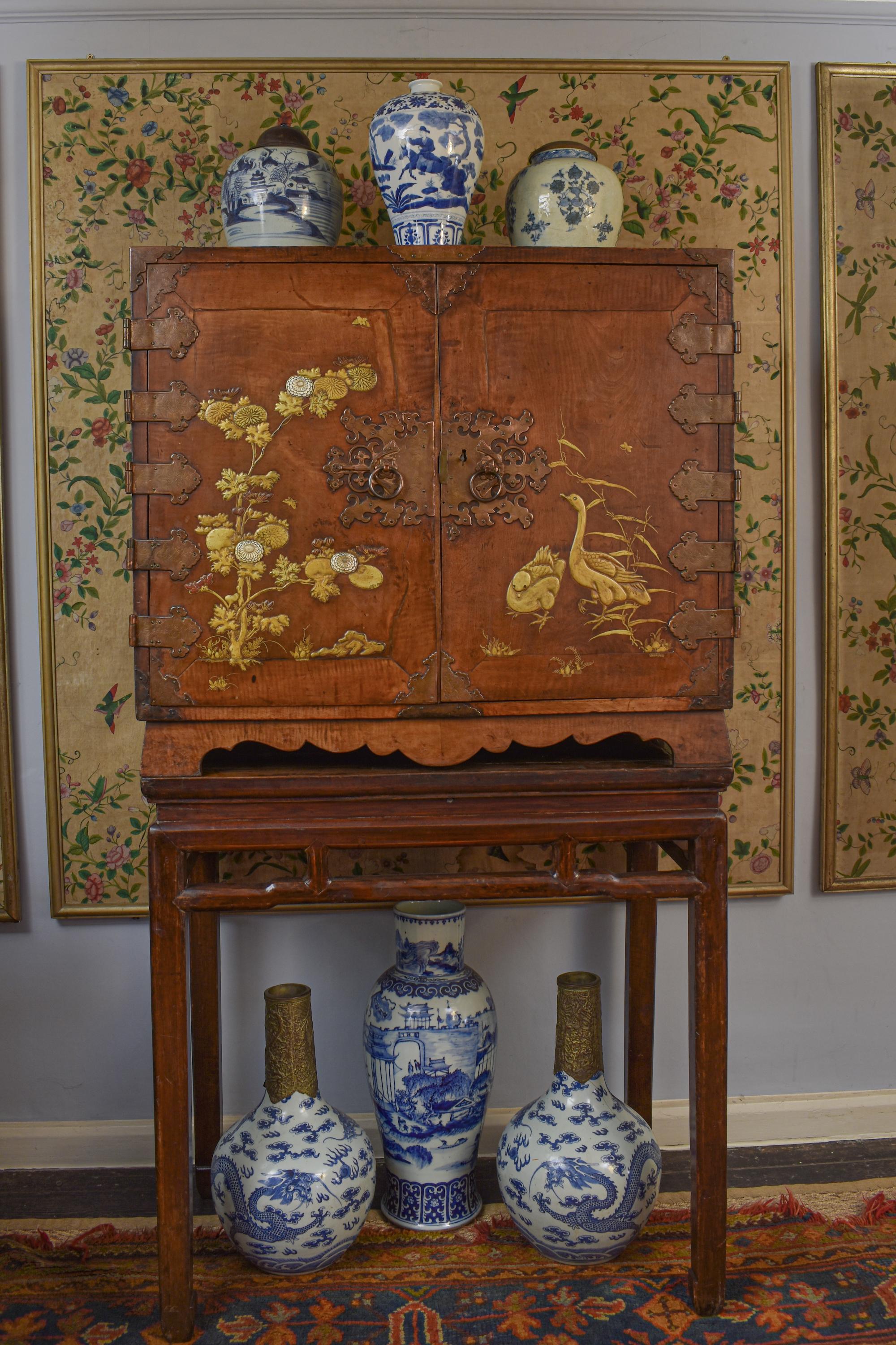 An outstanding and rare, 17th-century Japanese mulberrywood gilt-lacquer cabinet raised on a later stand.

This fine and exceptional two-door, gilt-heightened cabinet - reputedly in mountain mulberry wood - decorated in the typical Japanese manner