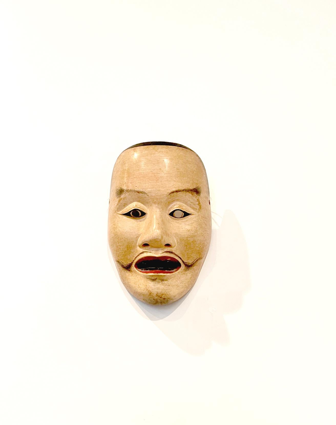 A painted wood mask for Noh theater signed by the artist Nakamura Fuseki and dated to 1824, of Edo period. The mask depicts the face of a Heita, which portrays the ghost of Genji generals and warriors in plays like Yashima and Ebira. It was finely