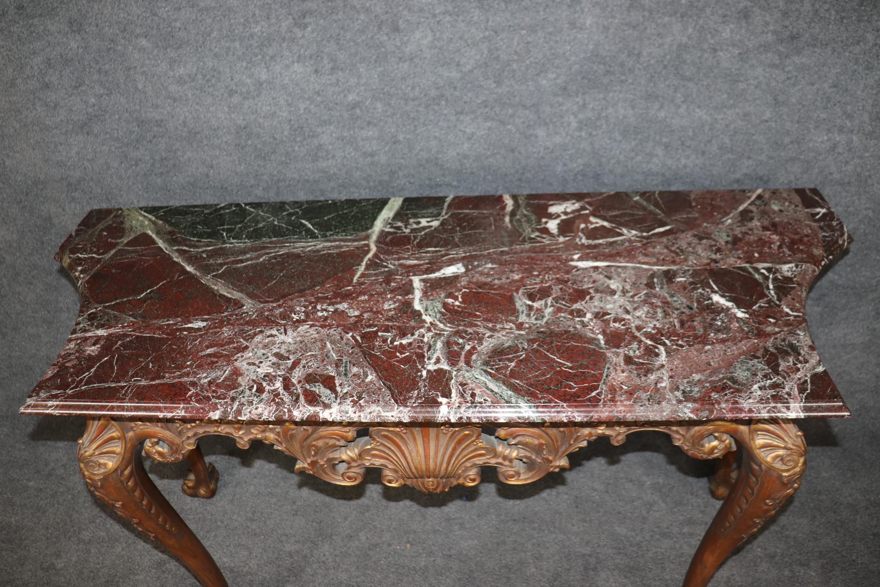 This is a spectacular pair of crisply carved, gold leaf gilded walnut consoles with fantastic patina and superb burgundy hued variegated marble tops. Look at the paw feet and gorgeous shell carving with floral and stylized acanthus leaves. The