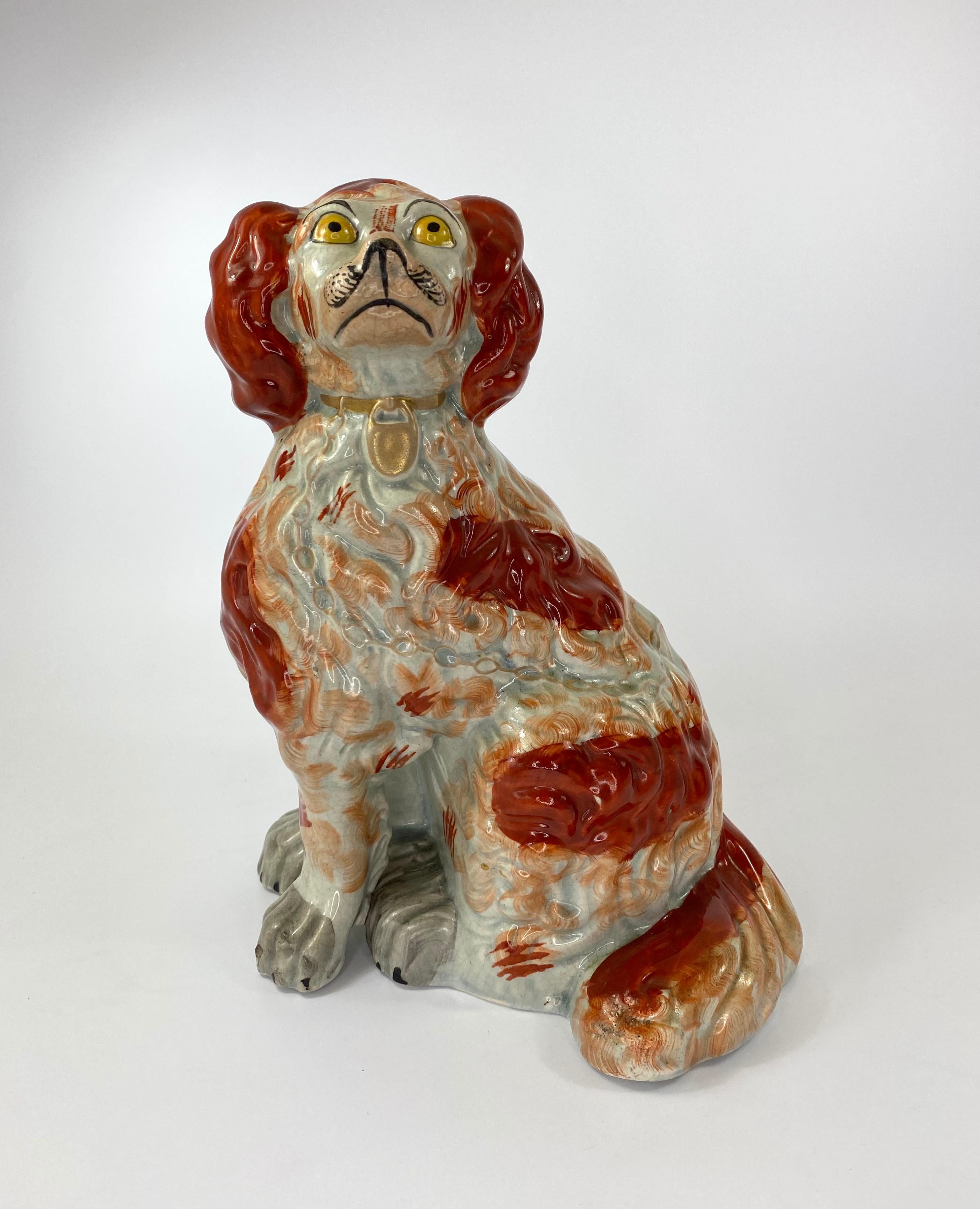An exceptionally fine, and large pair of Staffordshire pottery Spaniels, c.1840. Both seated dogs, with separate front legs, and broad backsides. Finely moulded hair, and painted with liver red spots, feathered at the edges. Having yellow eyes, grey