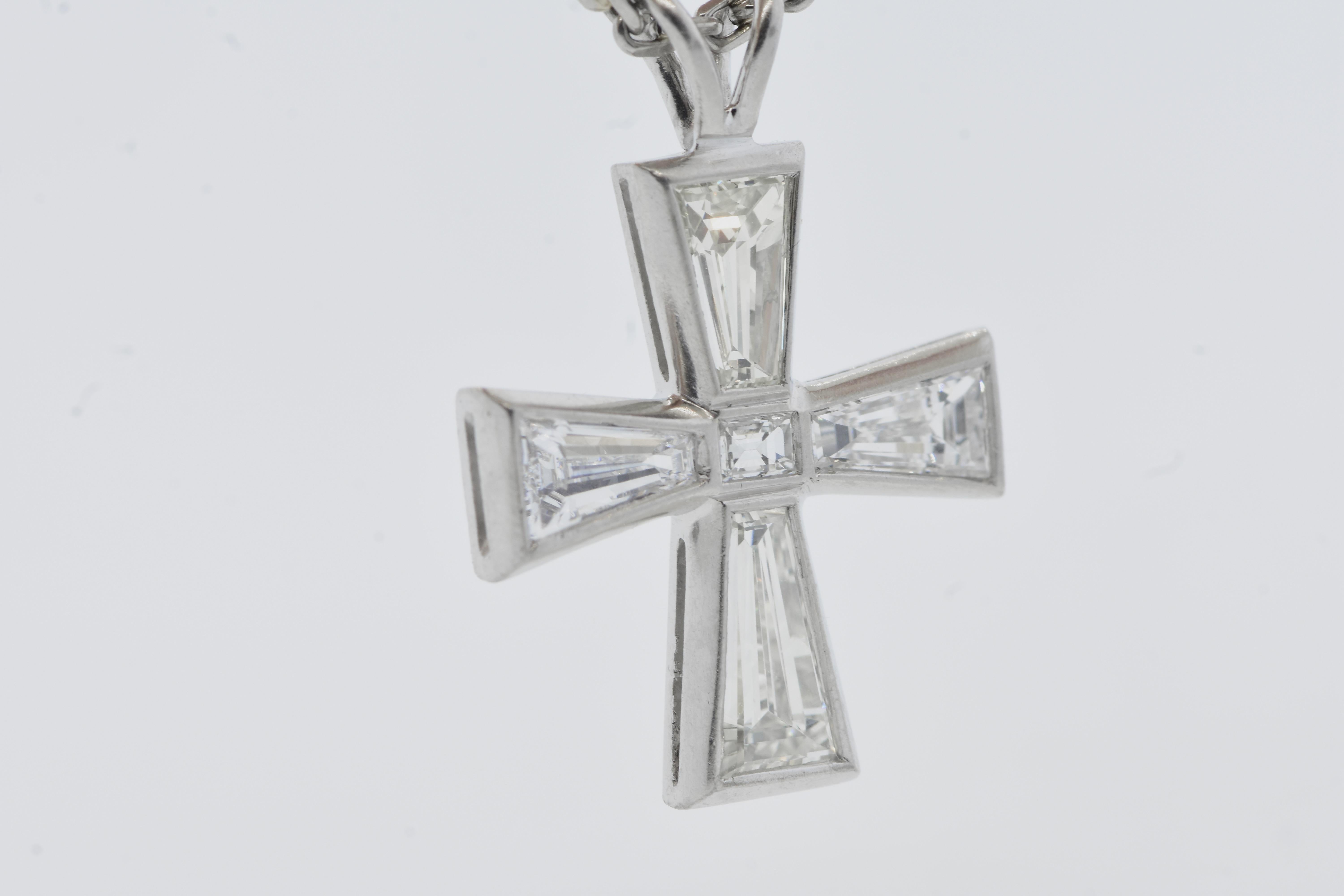 Diamond maltese cross composed of 4 fancy tapered baguette cut diamonds and a small rectangular cut diamond.  Resting on a platinum chain, this platinum maltese cross has an estimated 2.5 cts of fancy cut diamonds, bezel set and set girdle to