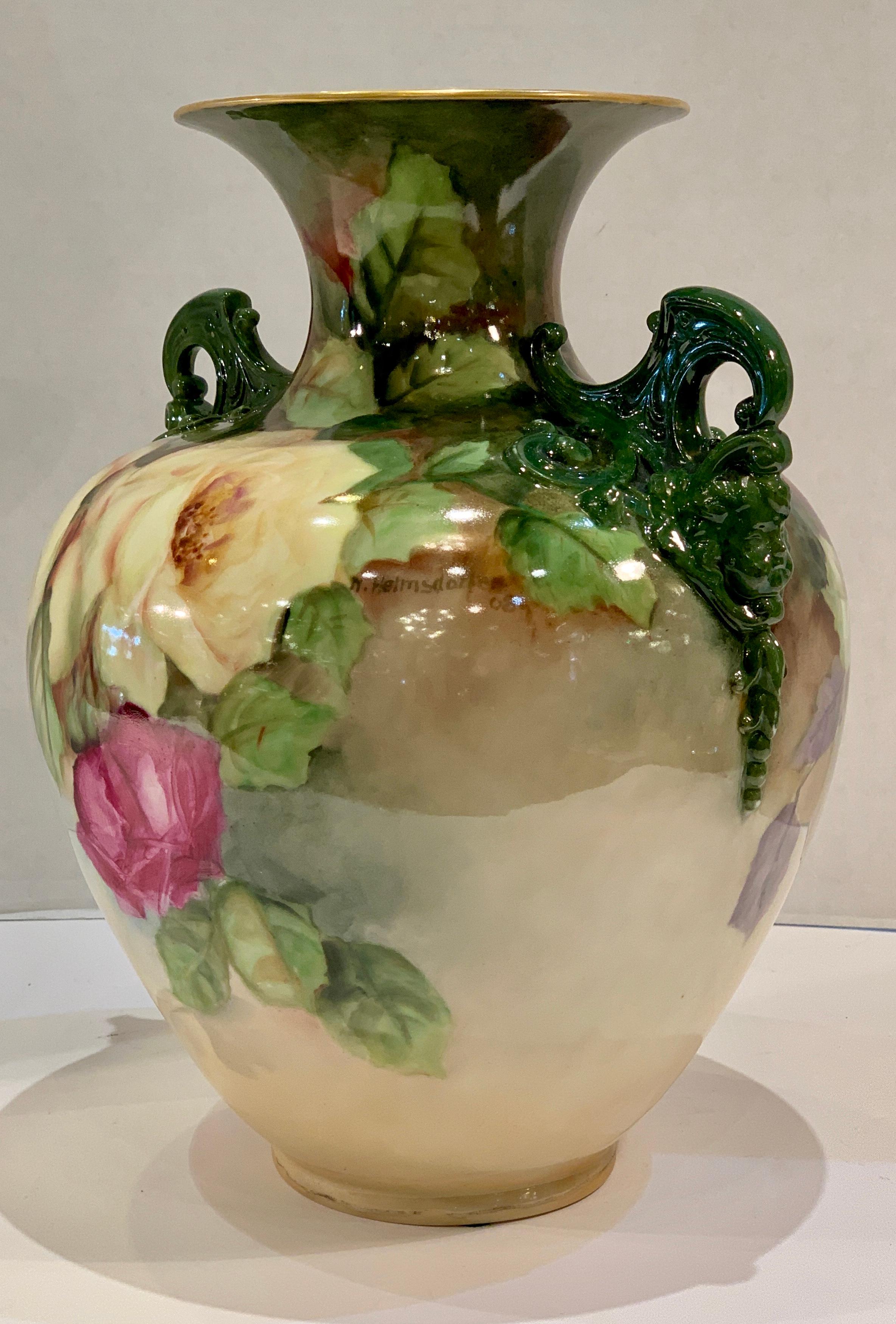 Beautiful hand made and hand painted antique American Belleek vase by the Lenox Ceramic Arts Company features very large, vivid clusters of fully blooming roses, high relief green cherub head handles and a 24-karat gold painted rim.

Vase is