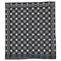 Alfombra antigua americana con motivos geométricos en azul y marfil
