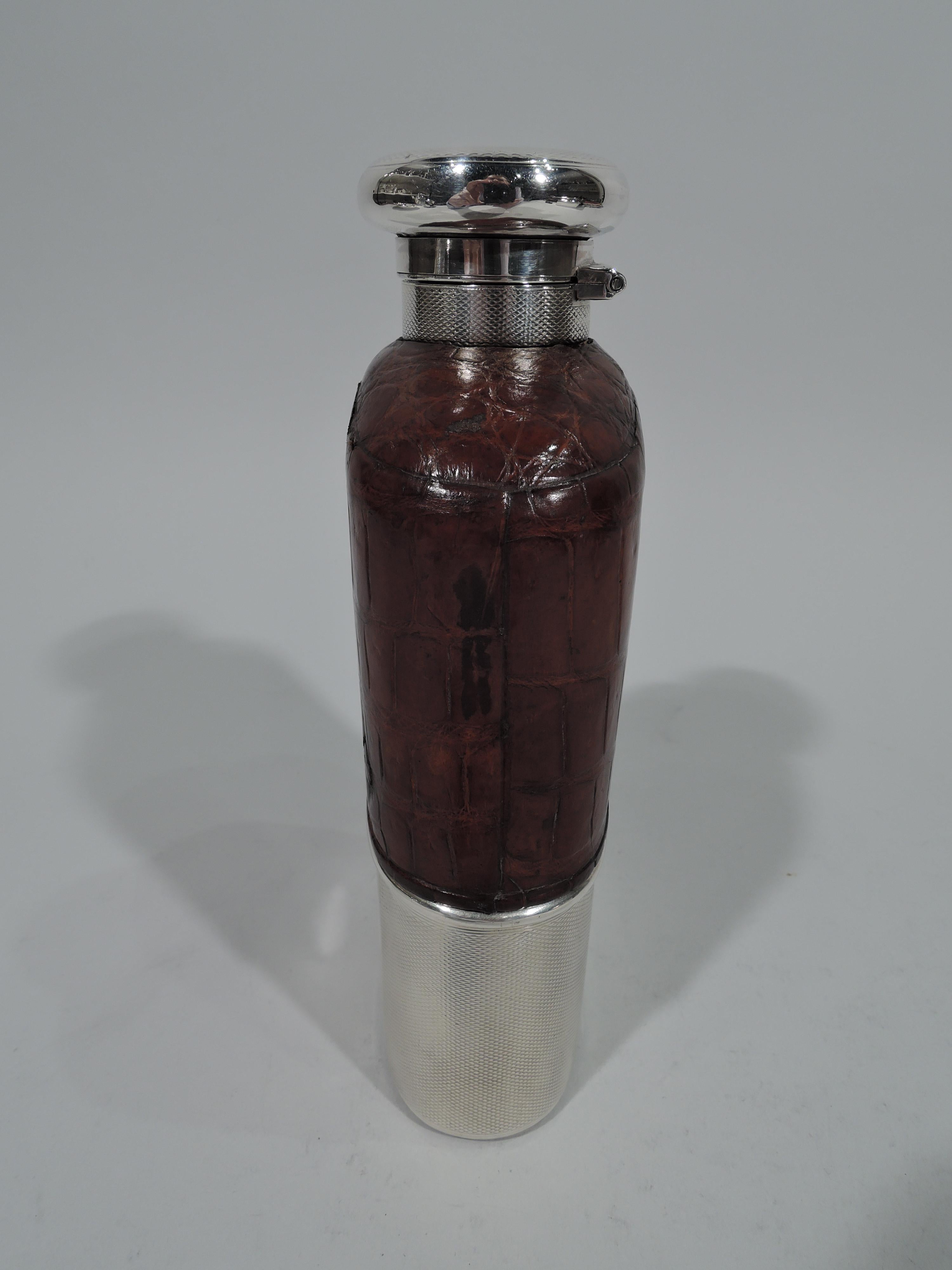 George V sterling silver and leather safari flask. Made by Asprey in London in 1916. Flask is clear glass. Top part encased in leather with cutaway vertical windows to measure how much booze is left. Bottom is detachable and engine-turned sterling
