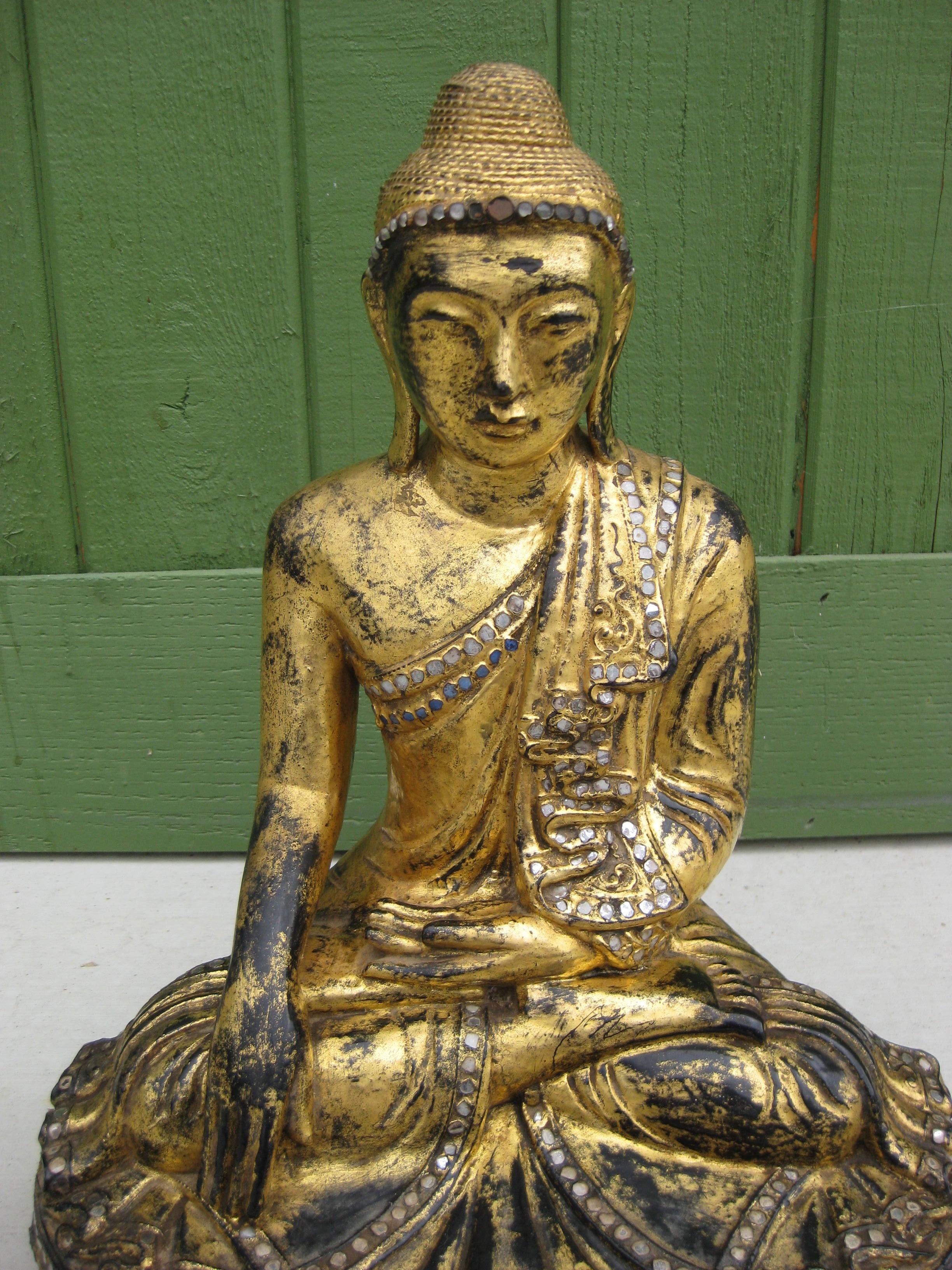 Statue en bois sculpté à la main de la divinité du Bouddha, temple birman de l'Asie du Sud-Est Mandalay, 19e siècle. Sculptée en bois, elle est peinte à la main en or 24 carats sur une laque noire. Pièces de verre incrustées pour la décoration.